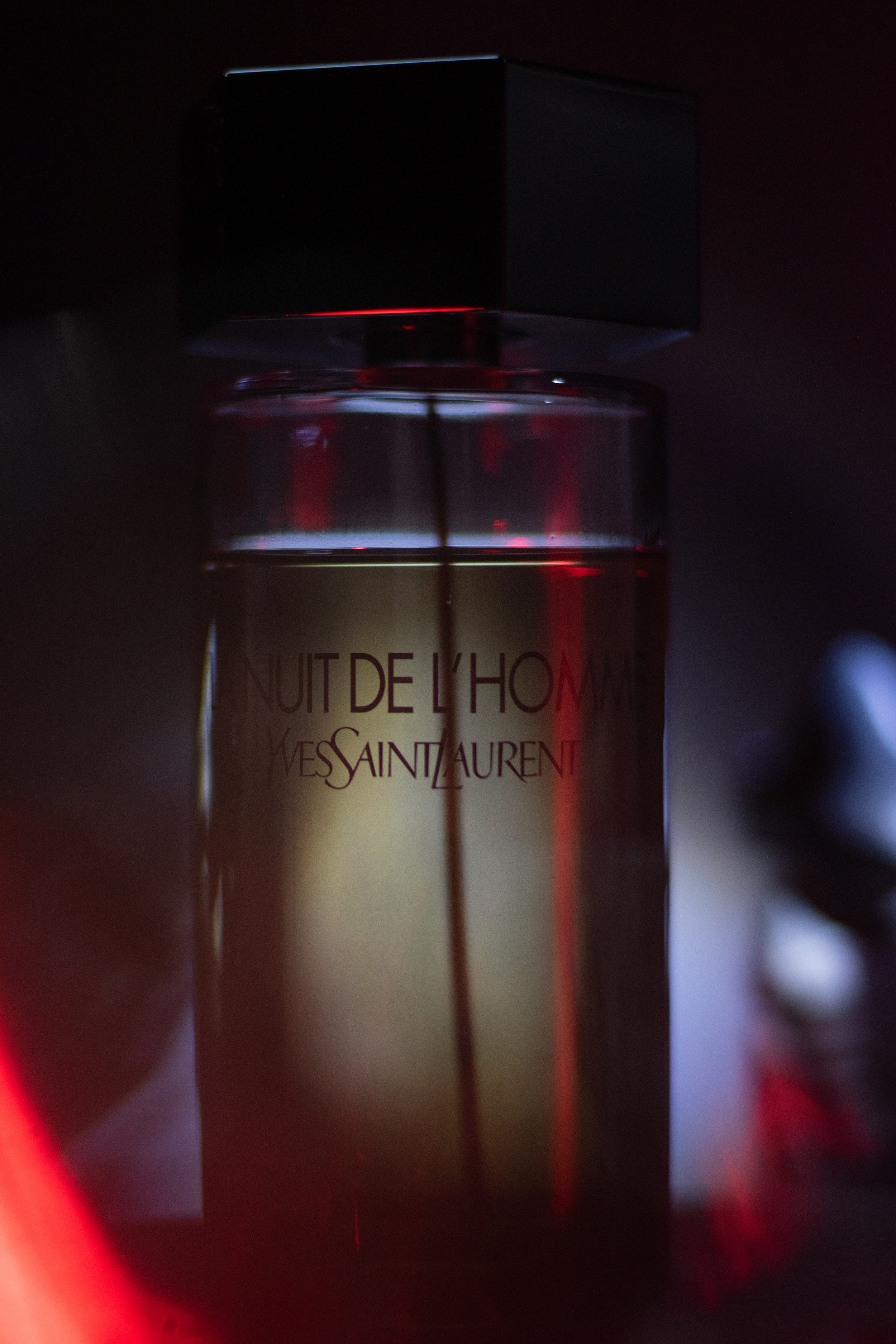 La Nuit de L’Homme photographed with red cinematic lighting, casting soft shadows and creating a moody atmosphere.
