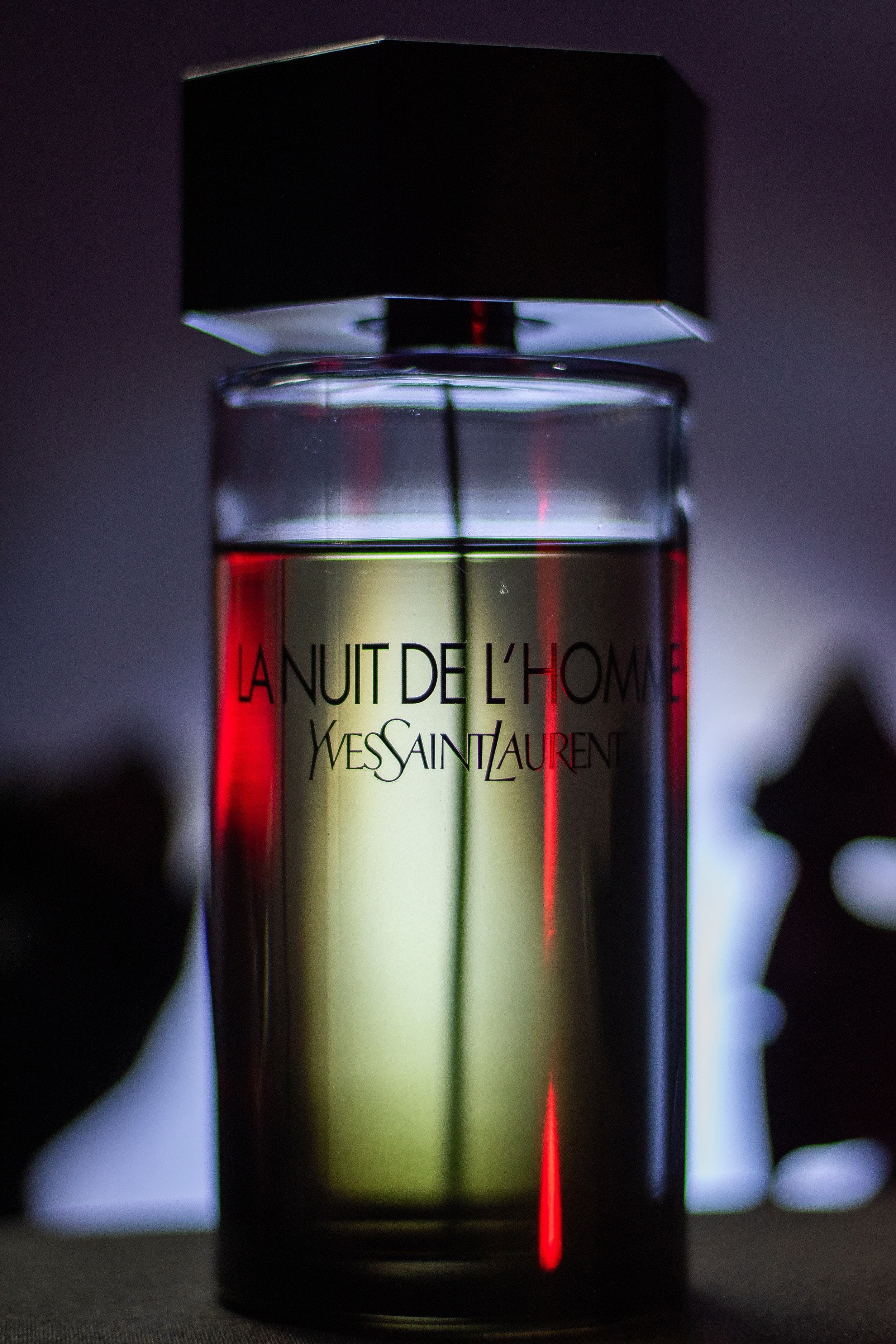 La Nuit de L’Homme in a cinematic scene, red accent lighting casting artistic shadows.