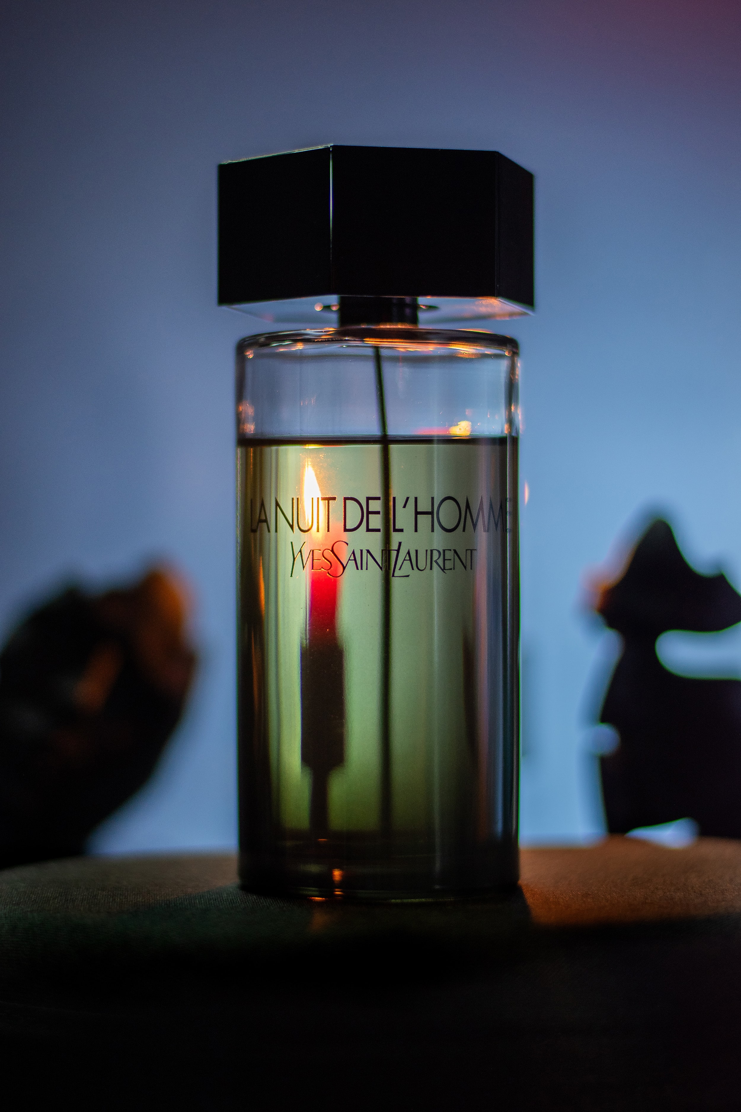 La Nuit de L’Homme in a film-inspired setup, red background lighting creating a luxurious feel.