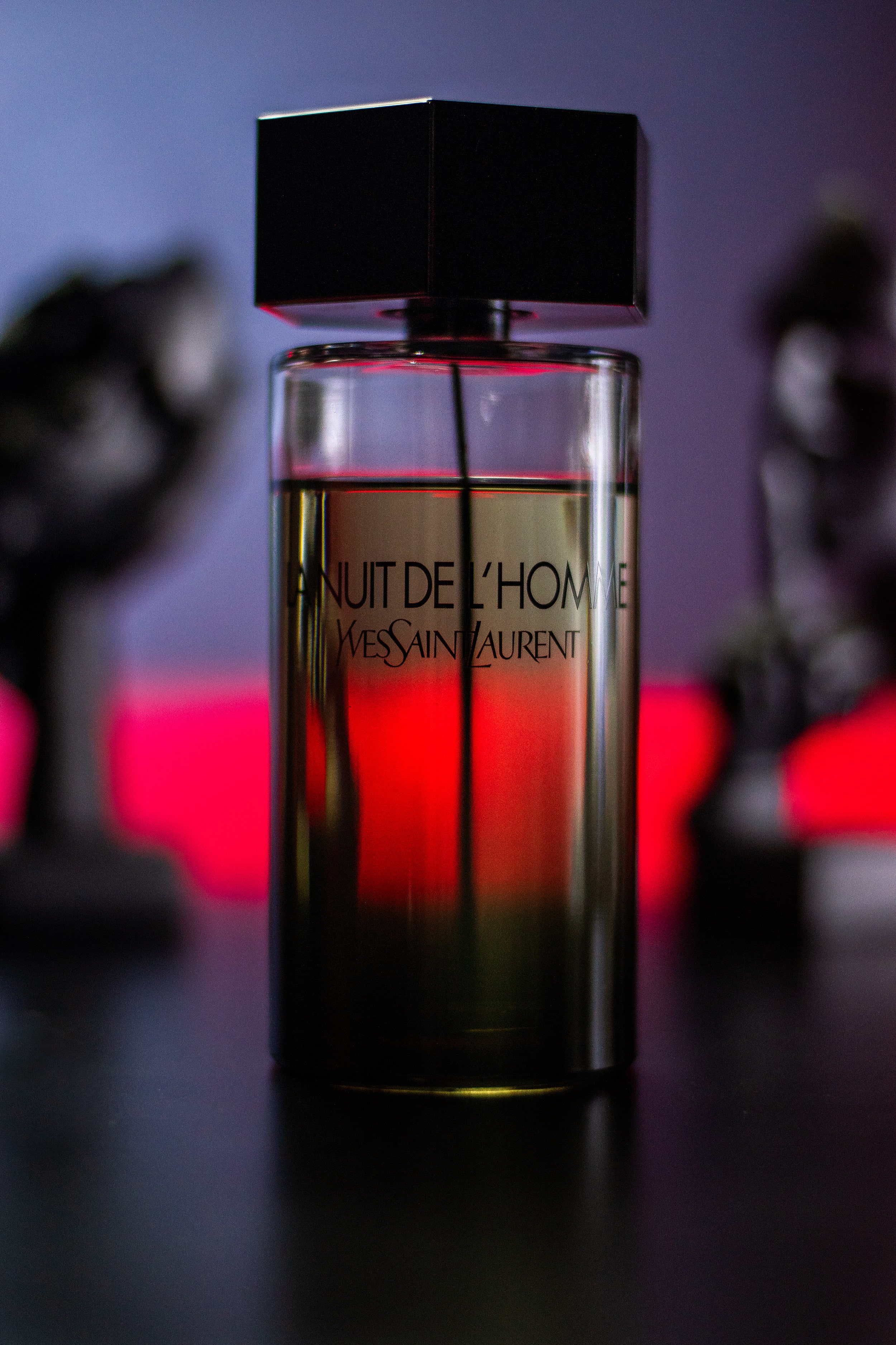 Close-up of La Nuit de L’Homme in a film-inspired scene, red light glowing in the background.