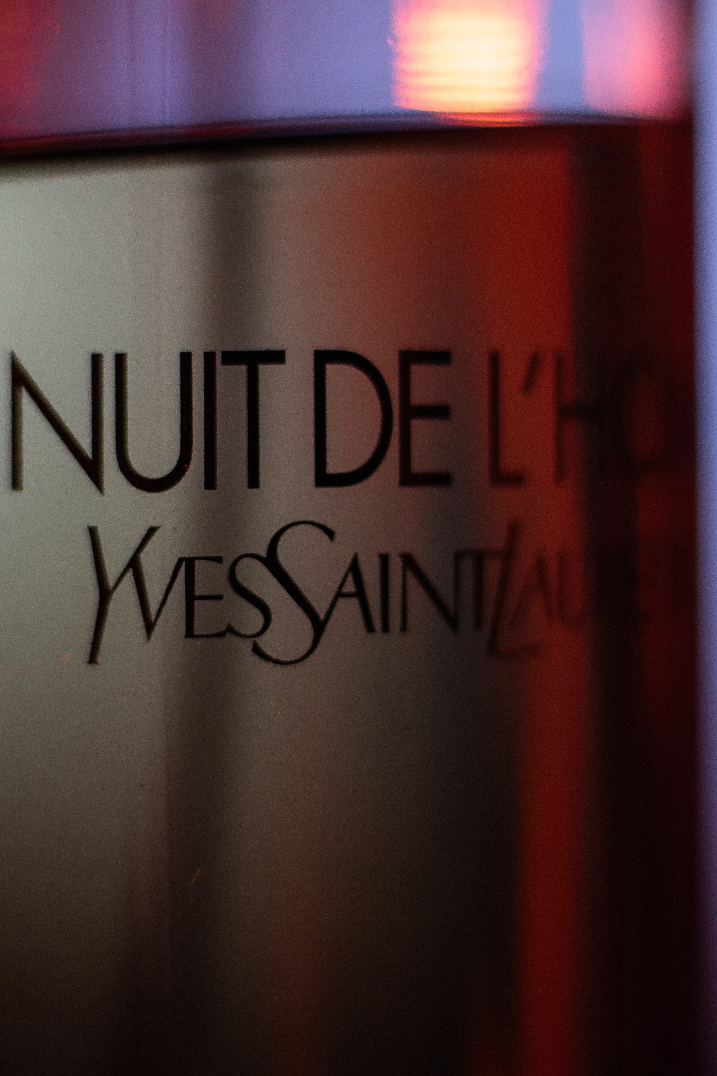 Front view of La Nuit de L’Homme with subtle red glow in the background, captured cinematically.