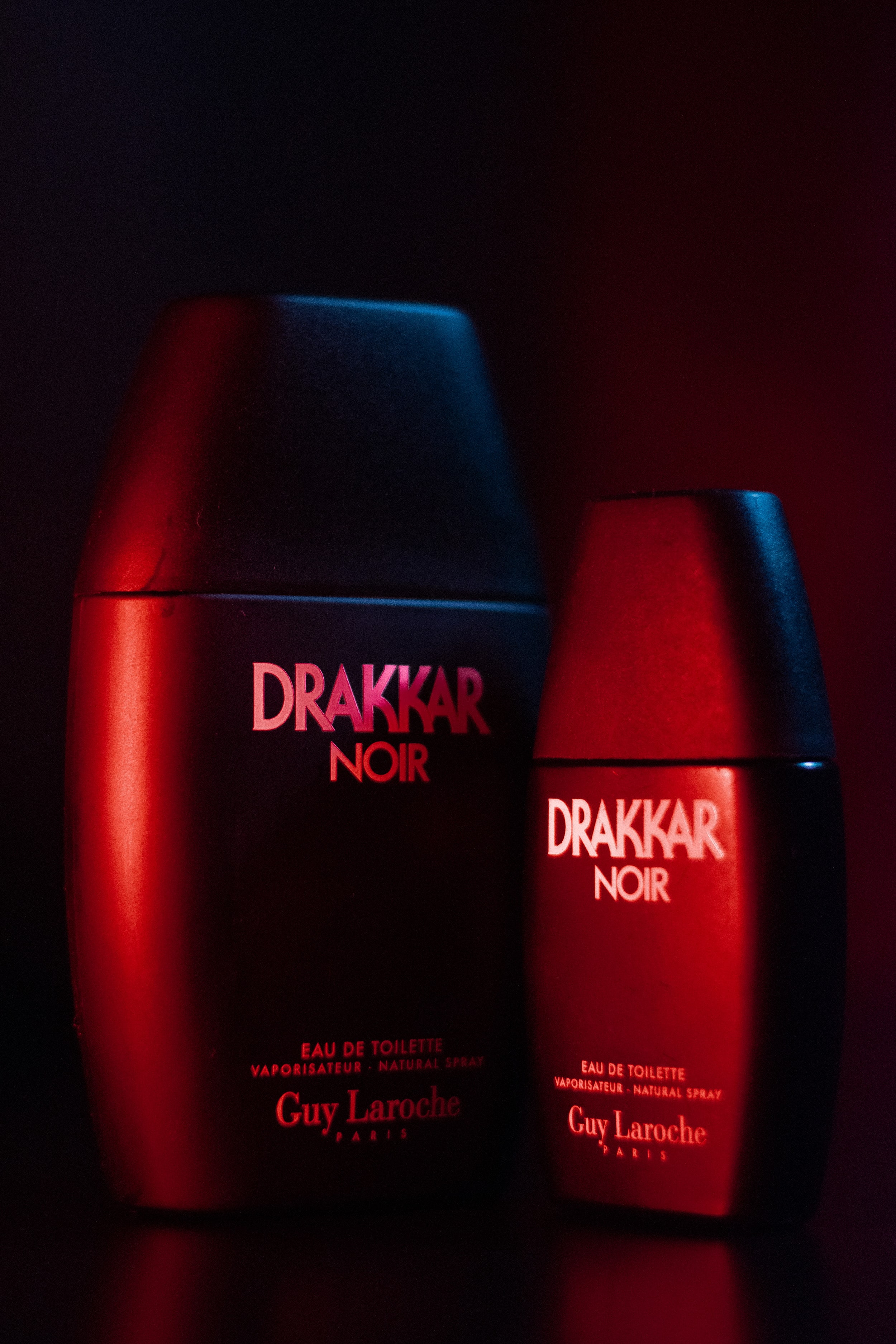 Drakker Cologne in a moody cinematic environment, red and blue lighting casting artistic shadows and highlights.