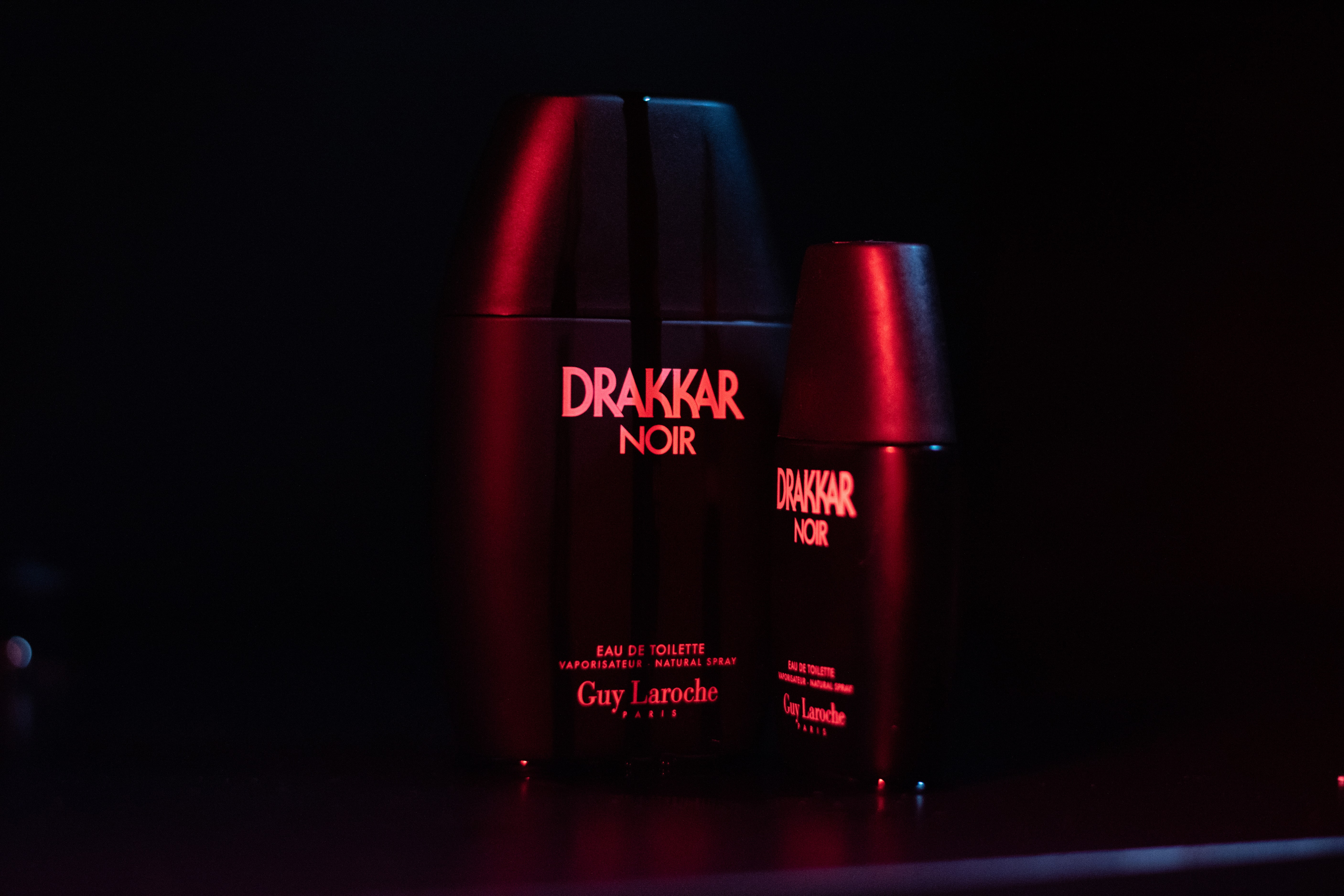 Angled shots of Drakker Cologne in a film-inspired setting, captured with cinematic blue and red lighting.