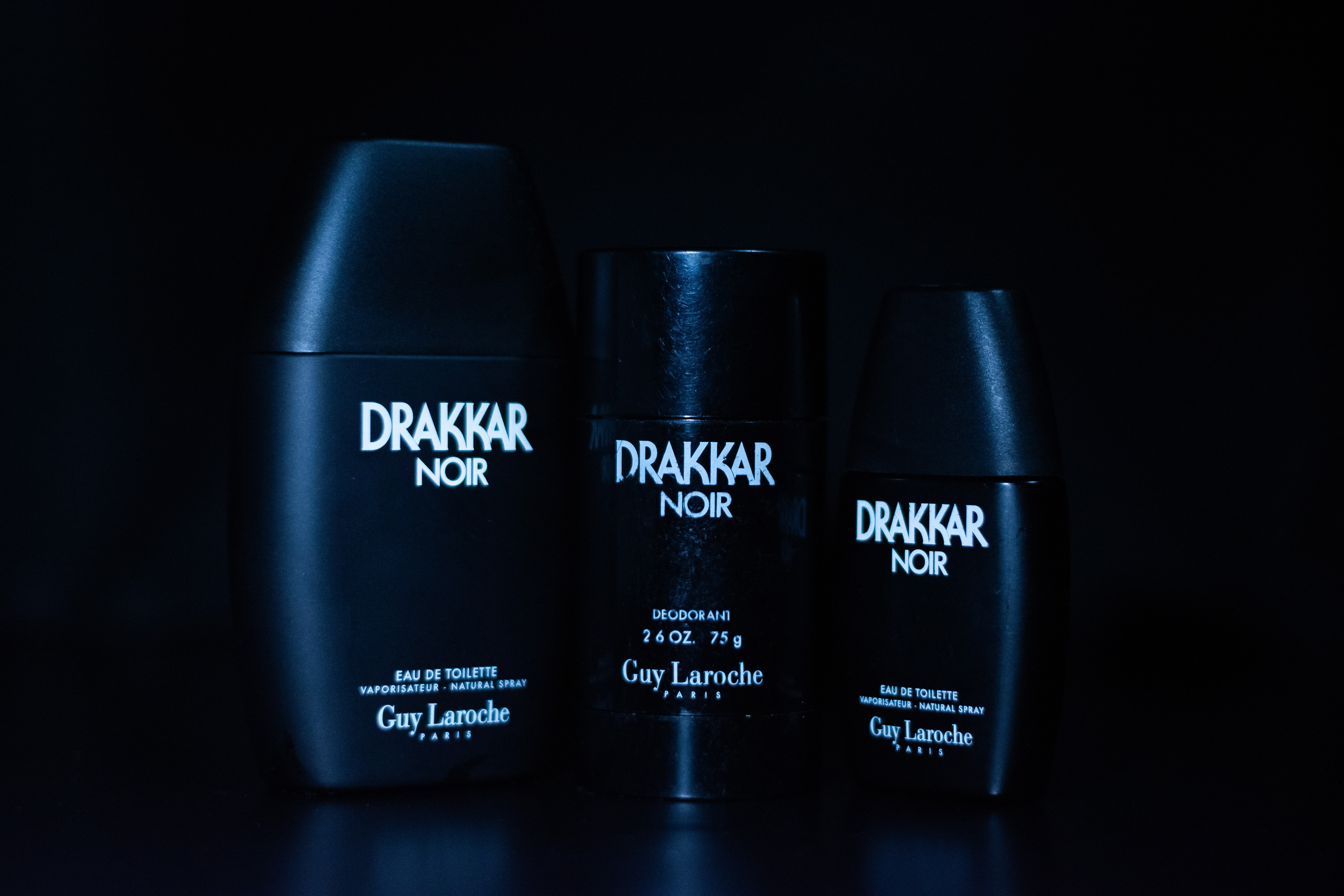 Drakker Cologne bottle in a film-inspired scene, photographed under contrasting blue lighting for a dramatic effect.