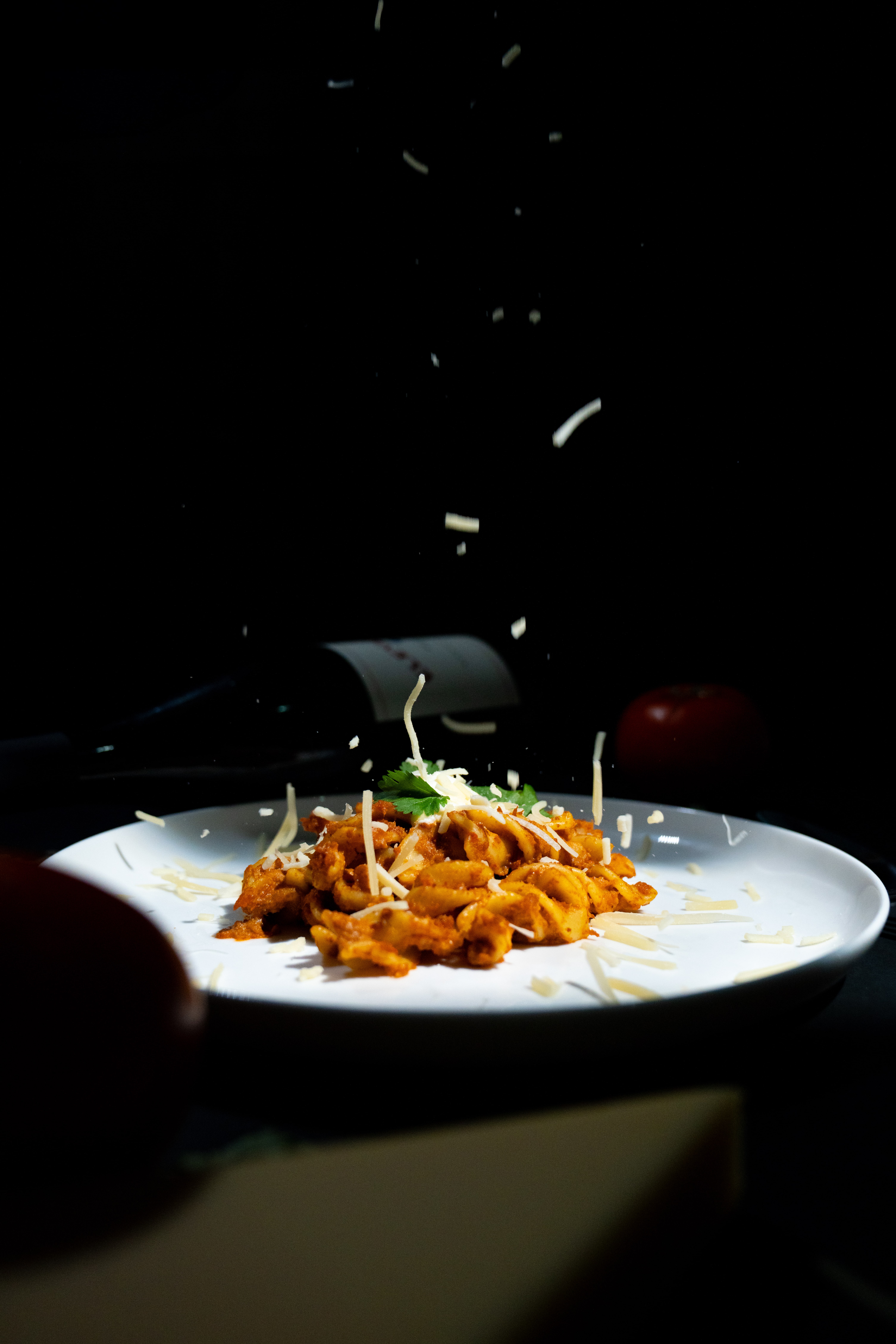 White plate of pasta captured with film-style lighting and atmospheric background.