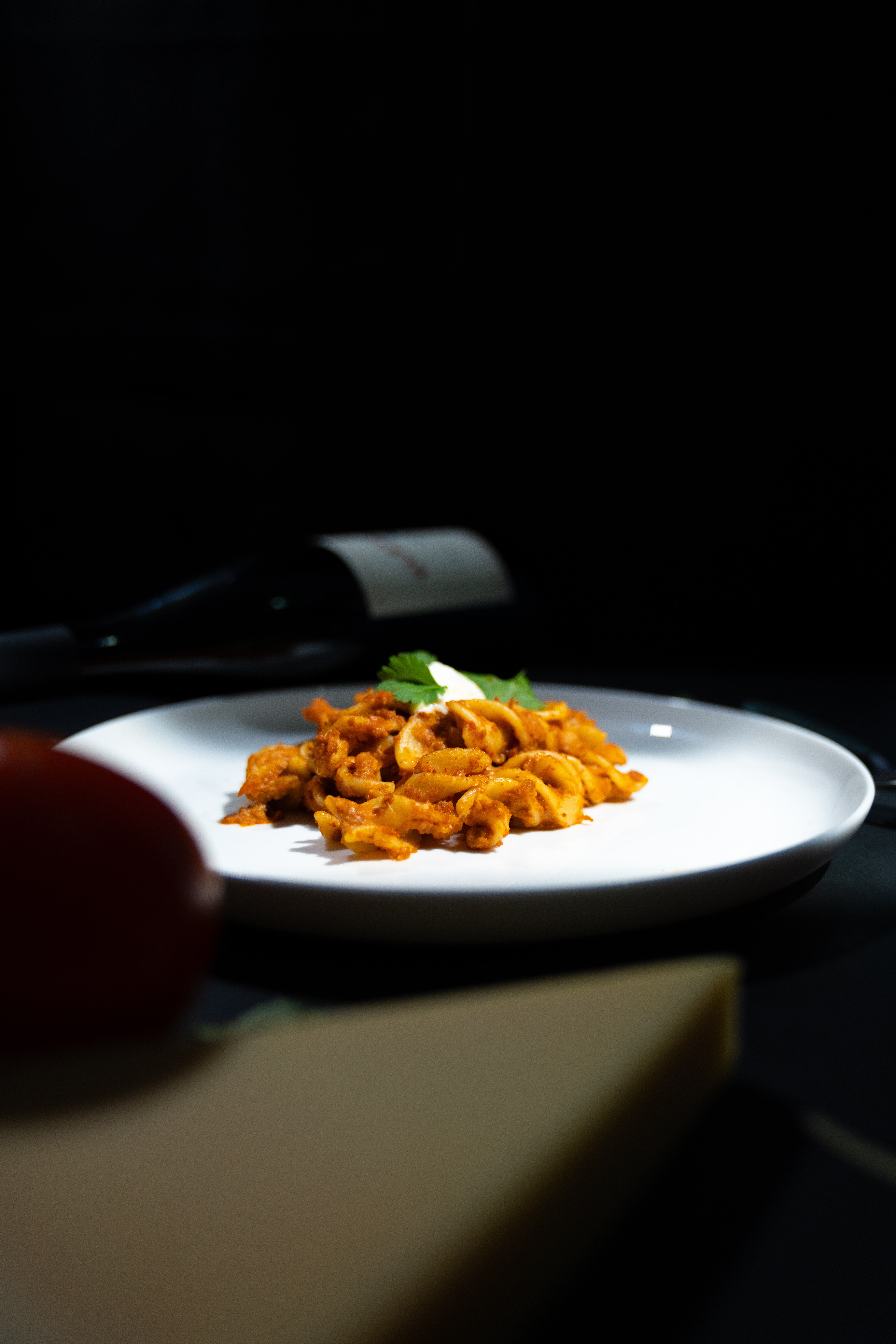Pasta on a white plate in a cinematic, film-inspired setting with shallow depth of field.