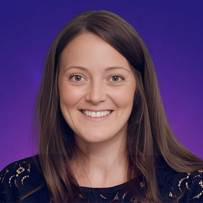A woman with long brown hair smiling at the camera.
