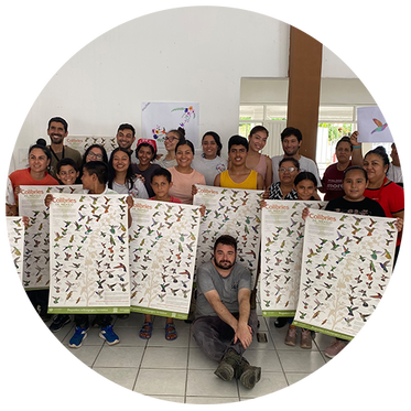 Group of people holding large posters displaying illustrations of various bird species called Collibries.