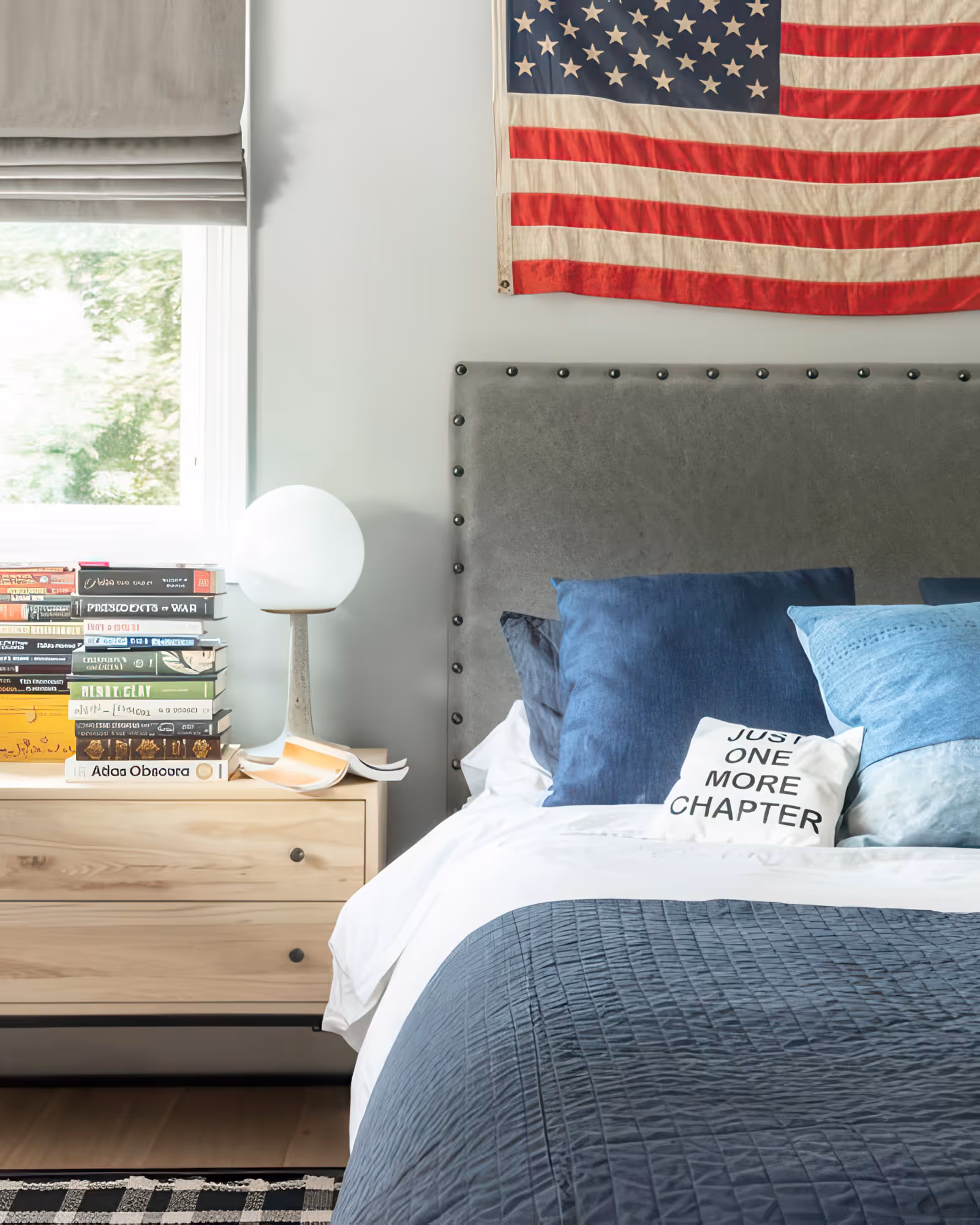 Contemporary teen boy bedroom featuring blue bedding, plush pillows, and an American flag accent wall in Encino, CA.