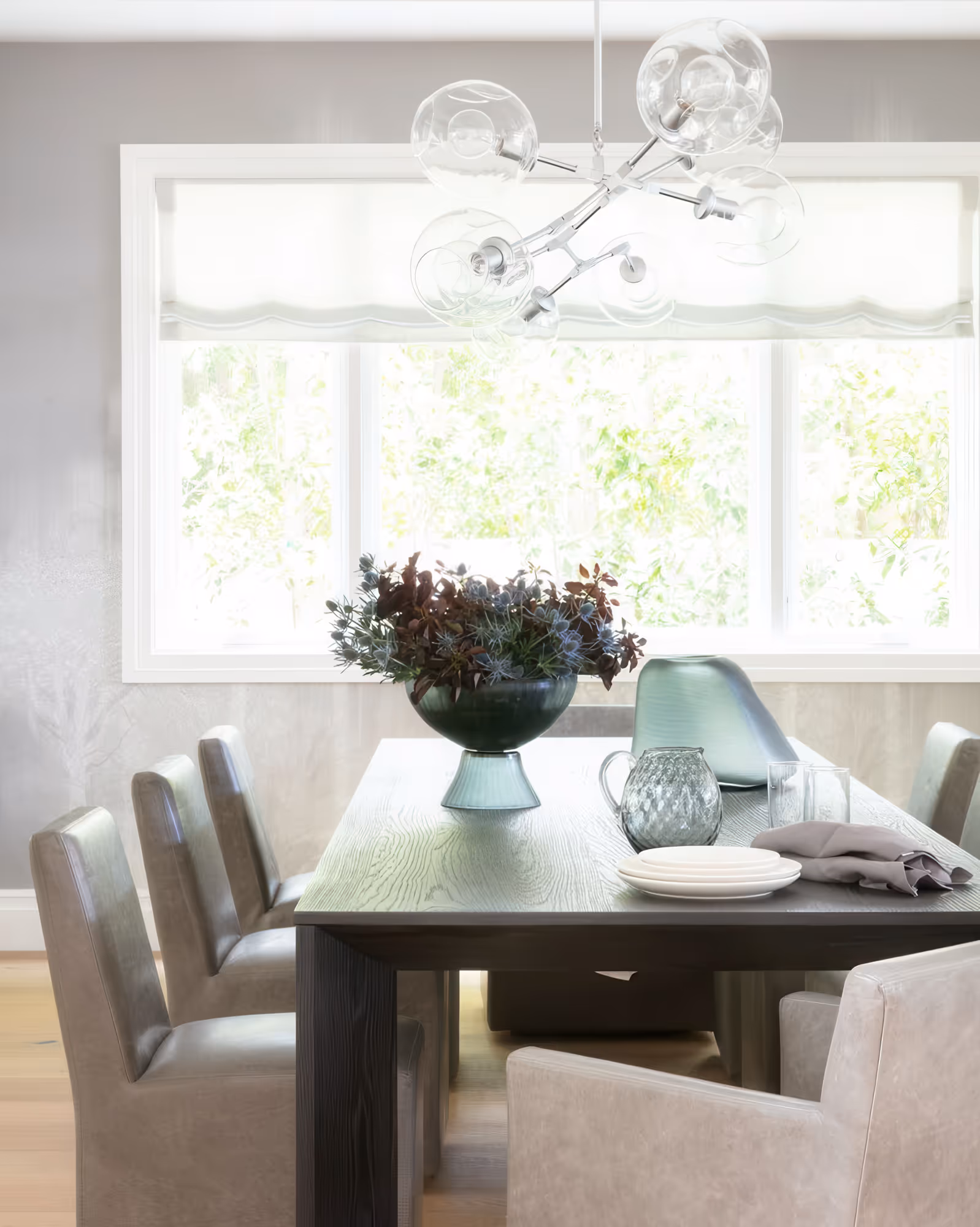 Elegant dining room featuring a modern chandelier and stylish gray upholstered chairs in encino, ca.