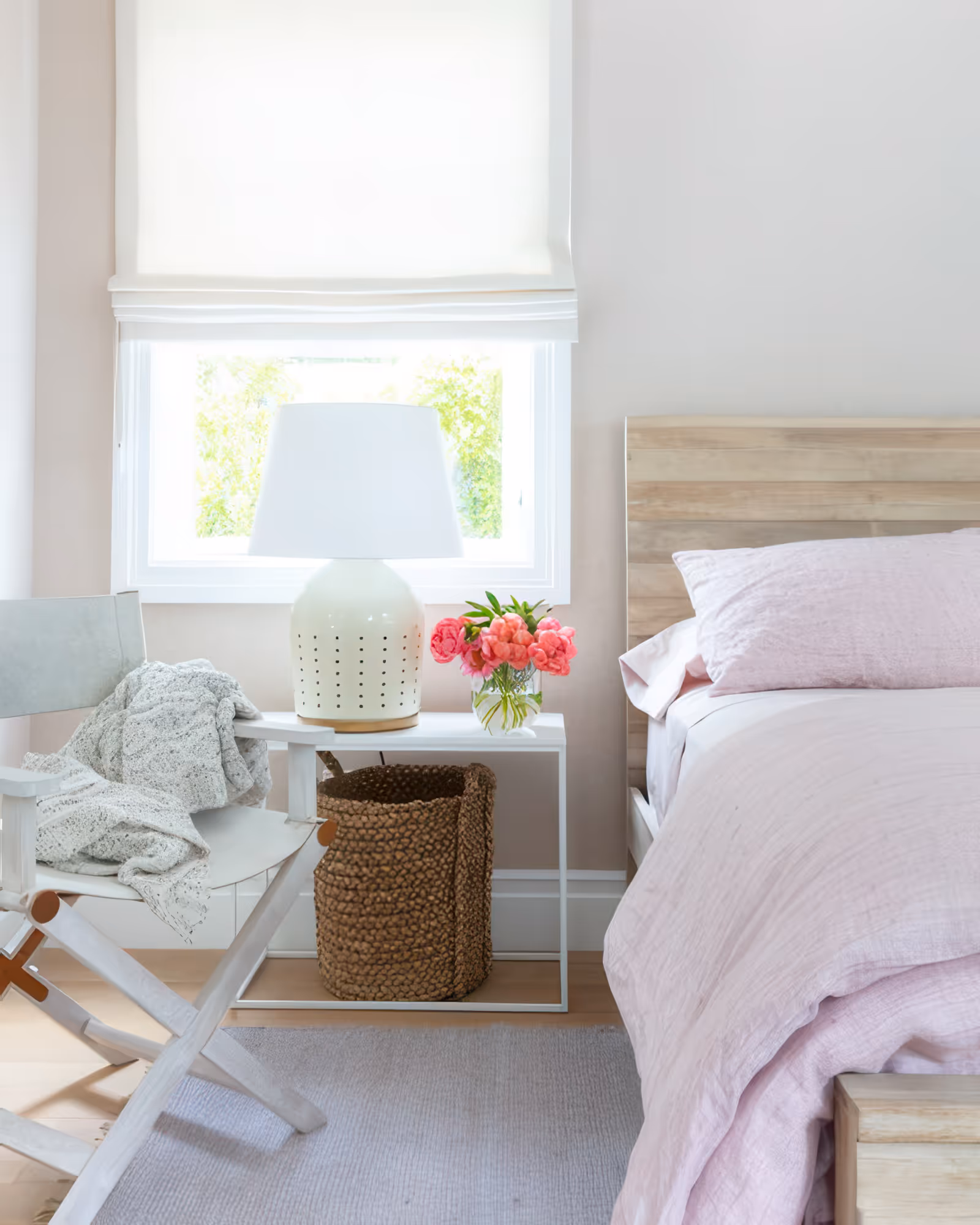 Modern bedroom in Encino, CA with pale pink bedding, wooden furniture, and a stylish lamp.