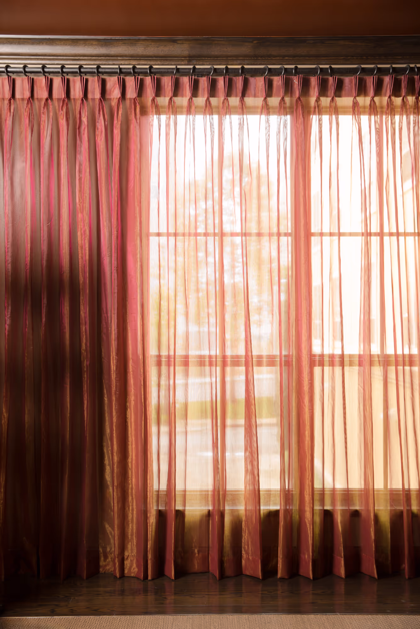 Sheer pink drapery enhancing a bright window in a Dallas, TX commercial setting, adding elegance to the room.