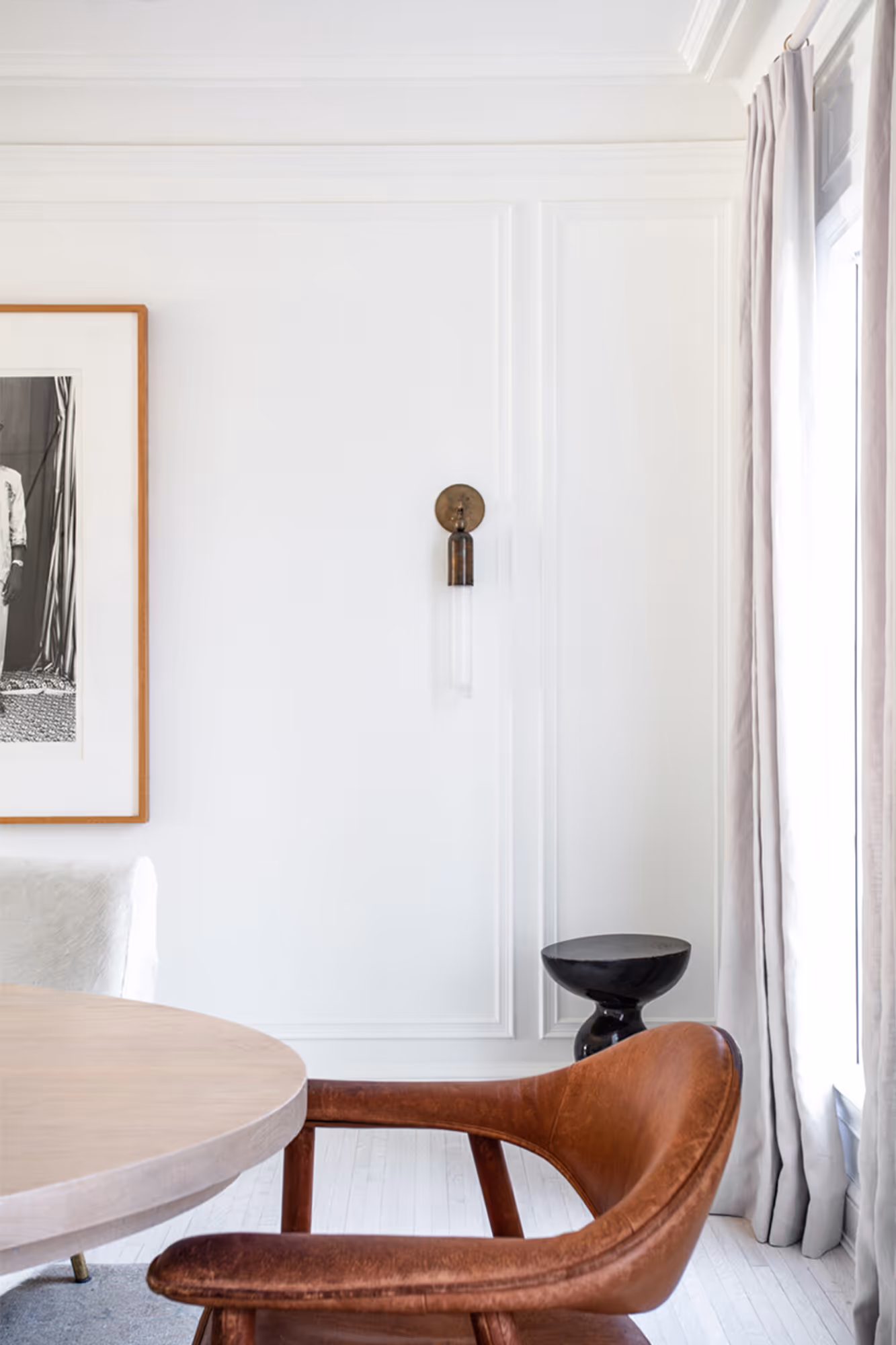 Elegant residential dining room in Hancock Park, CA featuring white walls, modern furnishings, and soft drapery.