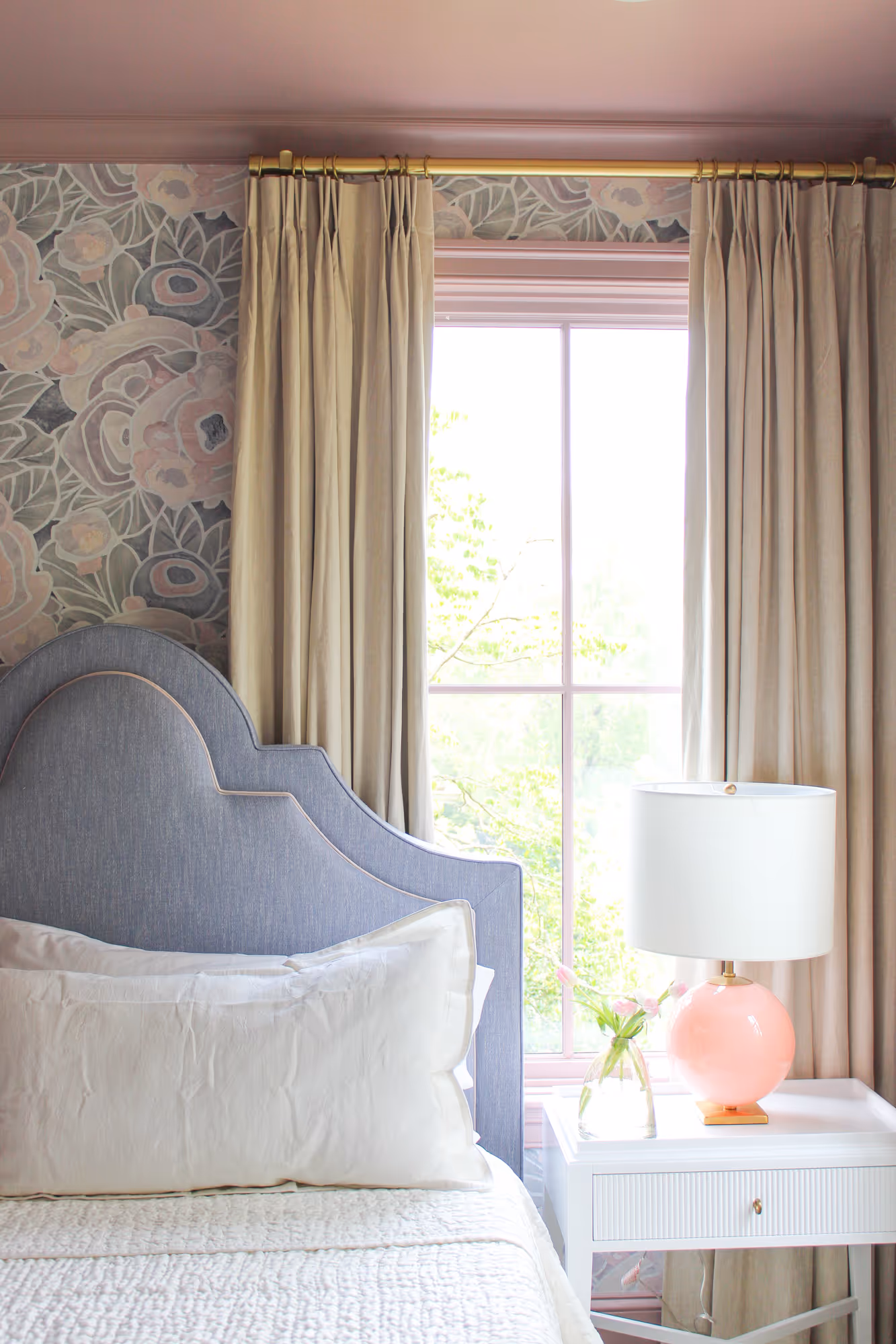 Charming girls bedroom featuring light beige drapery, floral wallpaper, and a pastel blue headboard in Arlington, VA.