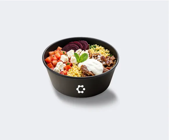 A black bowl with green soup topped with croutons and herbs, featuring a white Circus icon on the front.