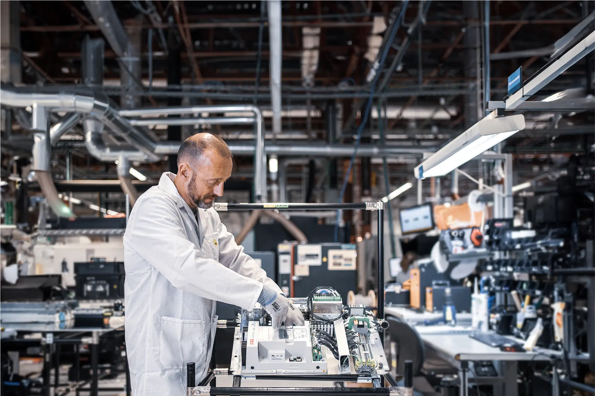Technician assembling internal electronic components for the CA-1 or CA-M automated cooking systems inside a high-tech manufacturing facility.