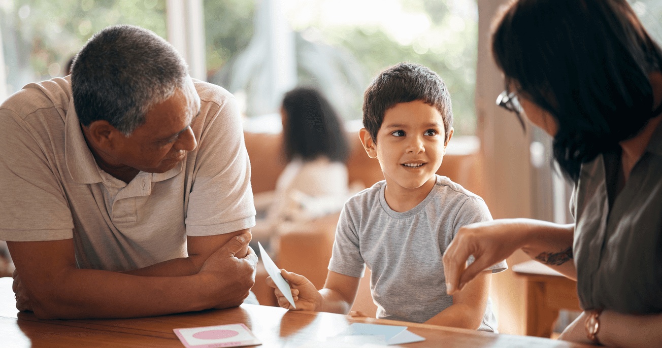 Parents working with a child during pivotal response training for children with autism to support communication and learning skills.