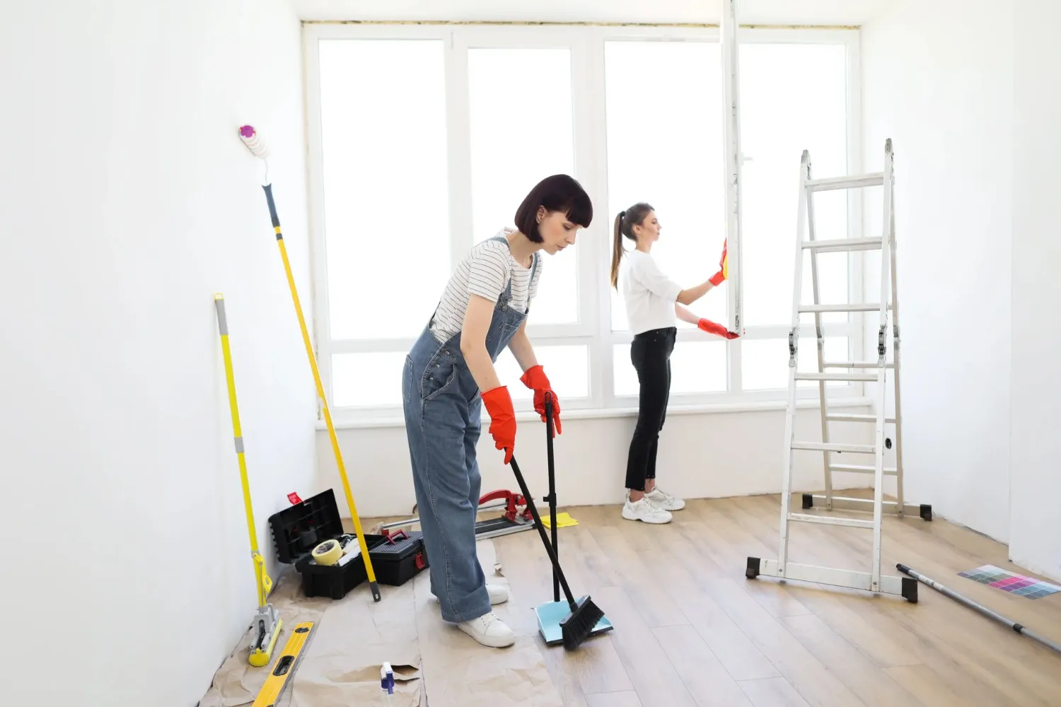 Two women cleaning a renovated room.