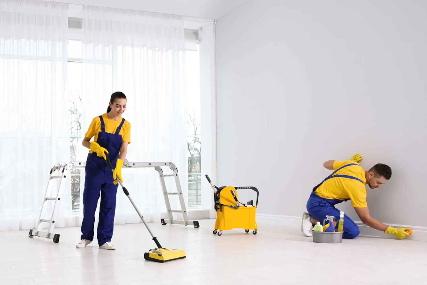 Professional cleaners cleaning an empty room.