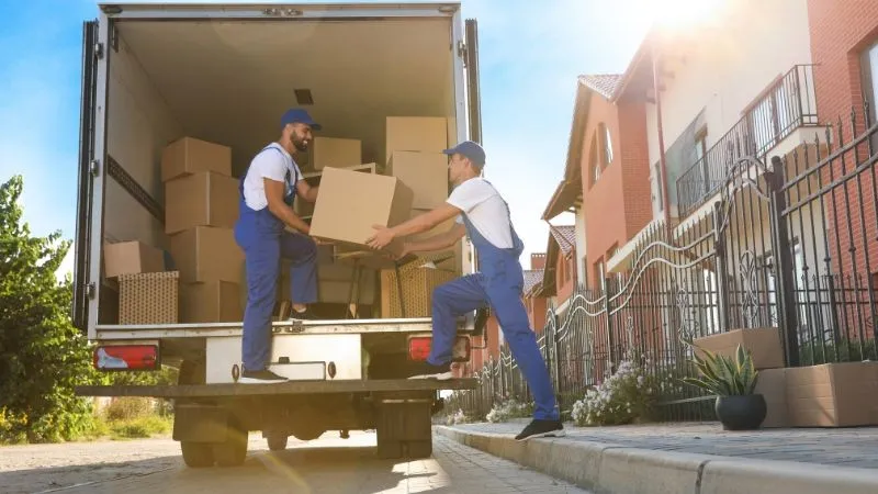 Professional movers loading boxes into truck.