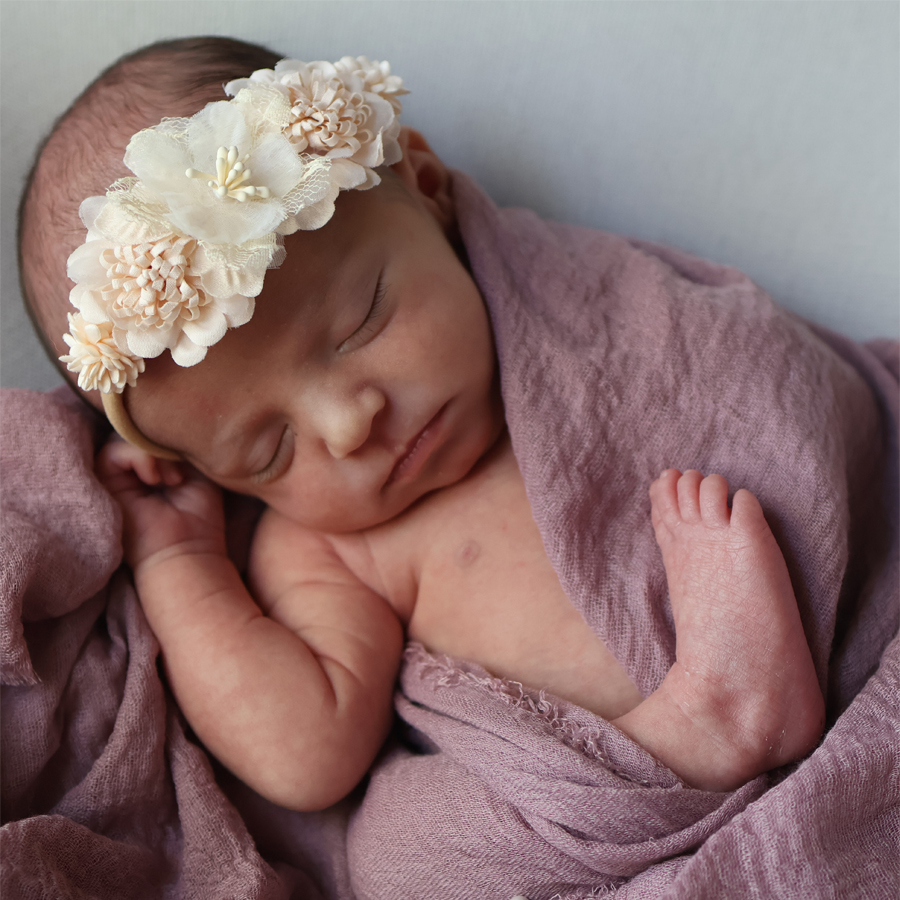 Ein Baby schläft friedlich in den Armen seiner Mutter – Symbol für Geborgenheit, Vertrauen und bindungsorientierte Schlafberatung bei Cozyfamily in Magdeburg.