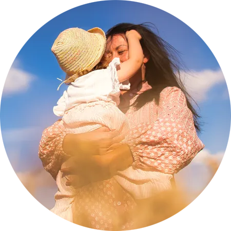 Jessi von Cozyfamily hält ihr Kind im Arm und lächelt vertrauensvoll in den warmen Sommertag – ein Bild voller Zuversicht und positiver Energie für ihren Blick in die Zukunft.