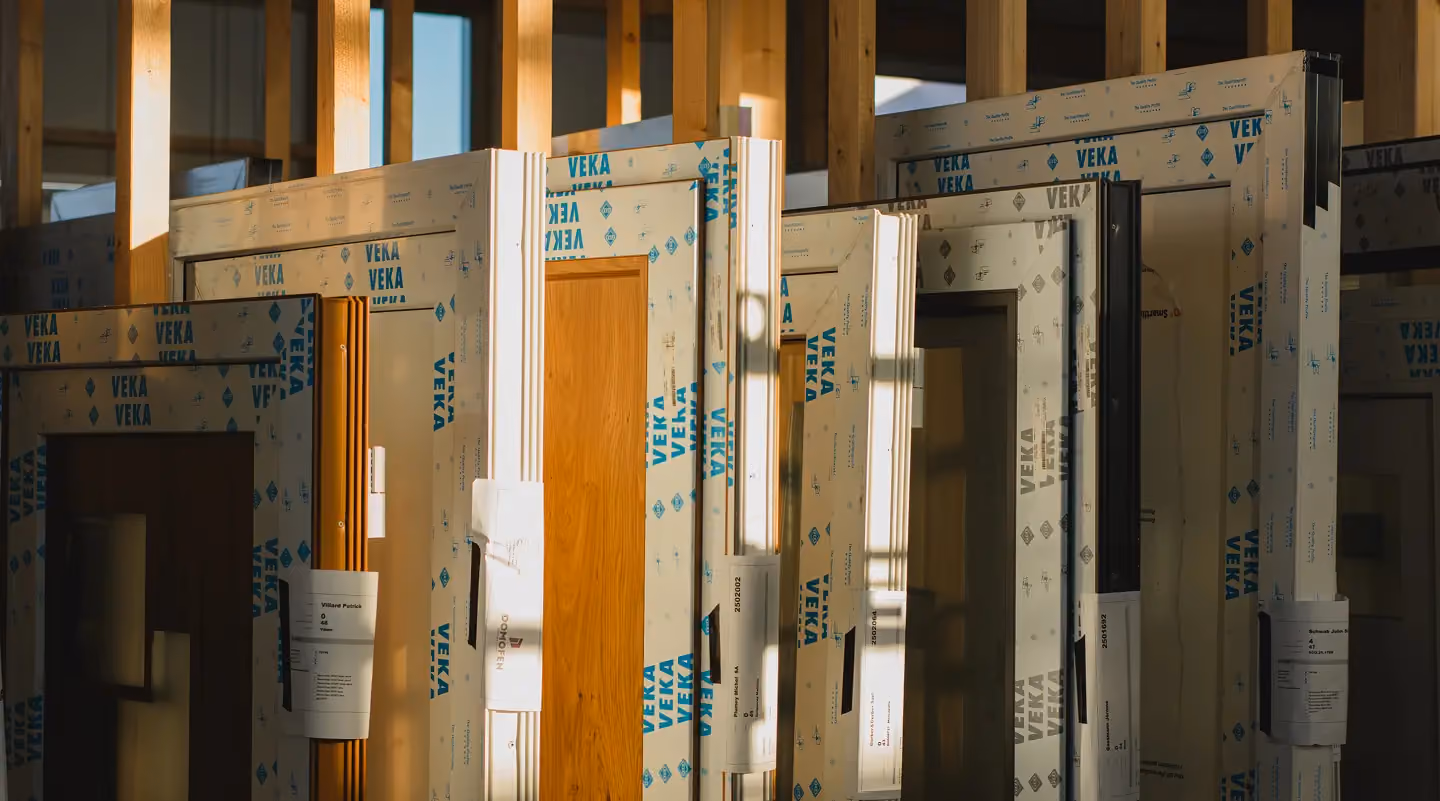 Cadres de fenêtres PVC VEKA emballés sur un chantier en bois