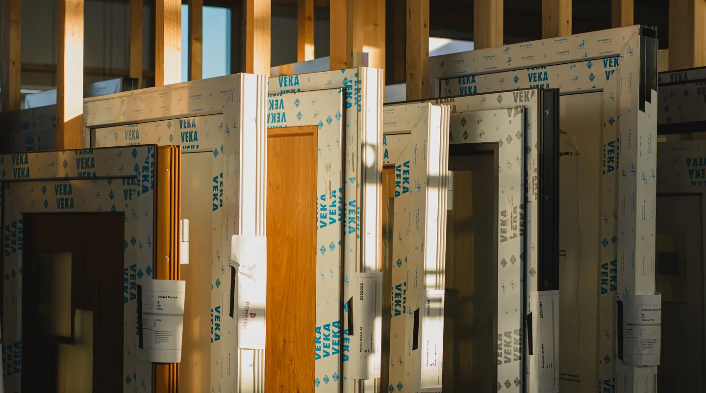 Cadres de fenêtres PVC VEKA emballés sur un chantier en bois