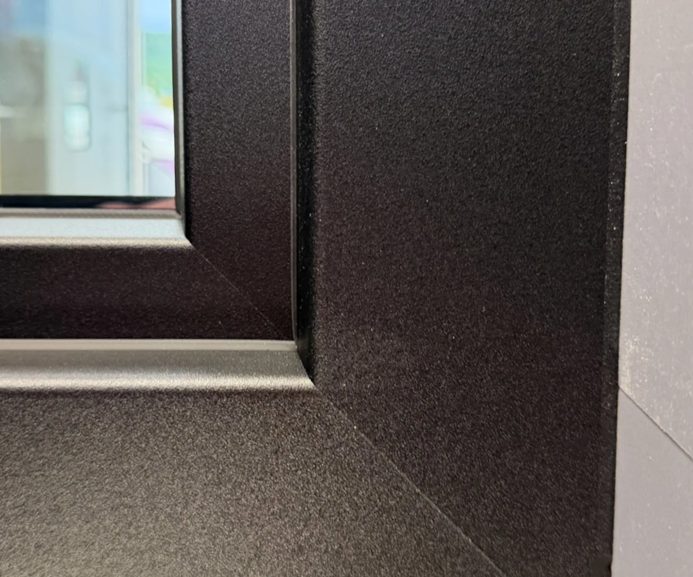 Gros plan sur l'angle d'un profilé VEKA en finition anthracite structurée