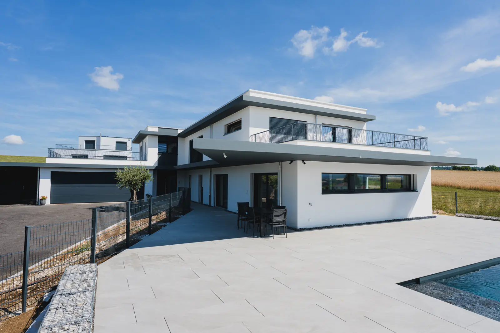 Villa contemporaine en Suisse romande équipée de fenêtres et portes-fenêtres en PVC Domofen, façade blanche et larges ouvertures