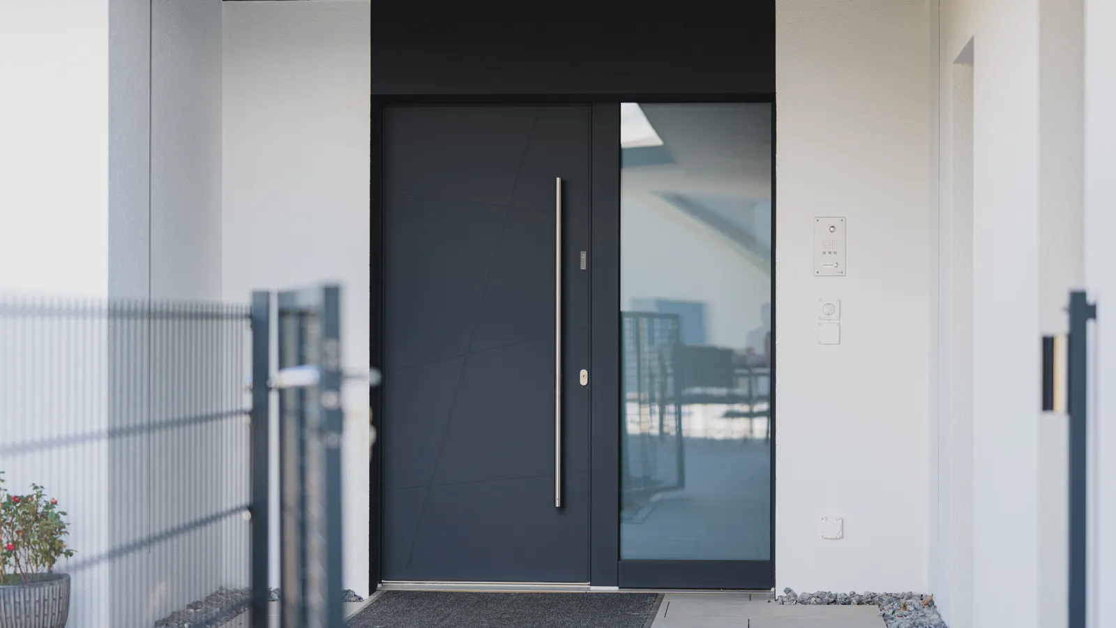 Porte d'entrée anthracite avec partie latérale vitrée sur une maison en Suisse, chantier Domofen