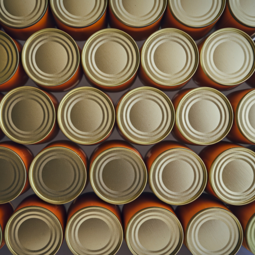 Vue en plongée de plusieurs boîtes de conserve alignées en rangées serrées.