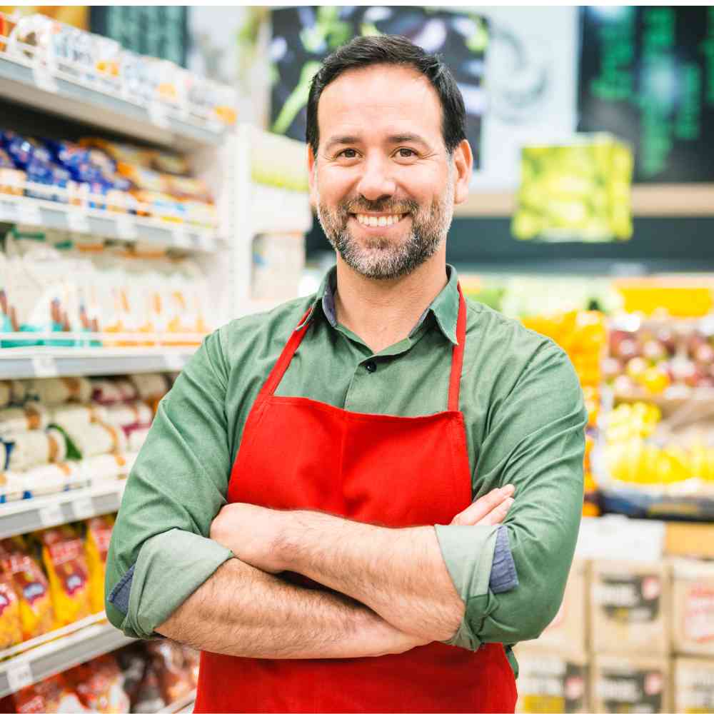 Employé libre-service disposant des fruits et légumes en rayon frais