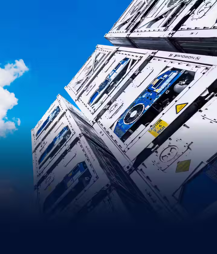 Stack of white refrigerated shipping containers with cooling units against a blue sky with clouds.