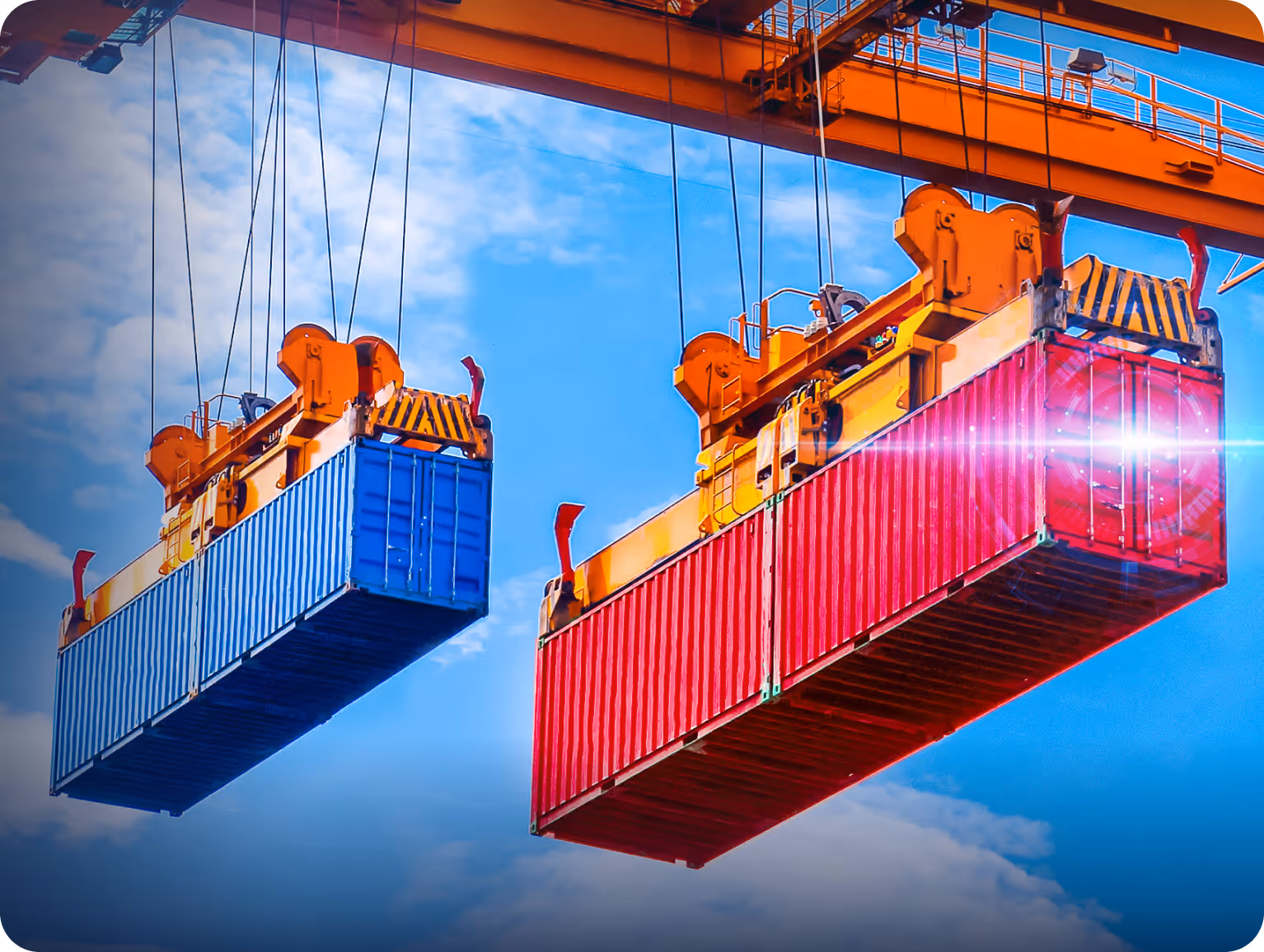 Dois grandes contêineres, um azul e um vermelho, suspensos por guindastes contra um céu azul com nuvens.