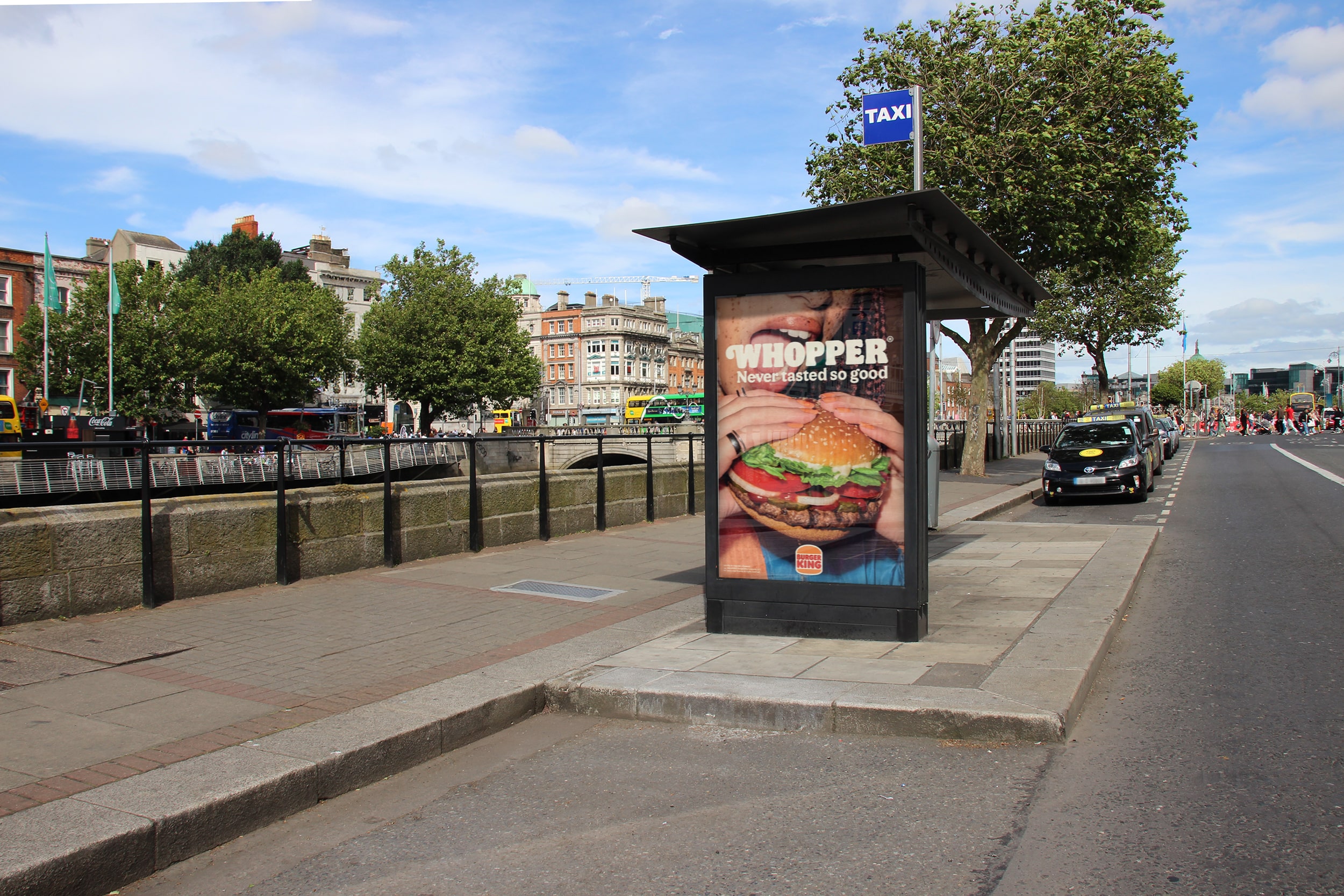 A classic bus shelter advertisement on a busy road 
