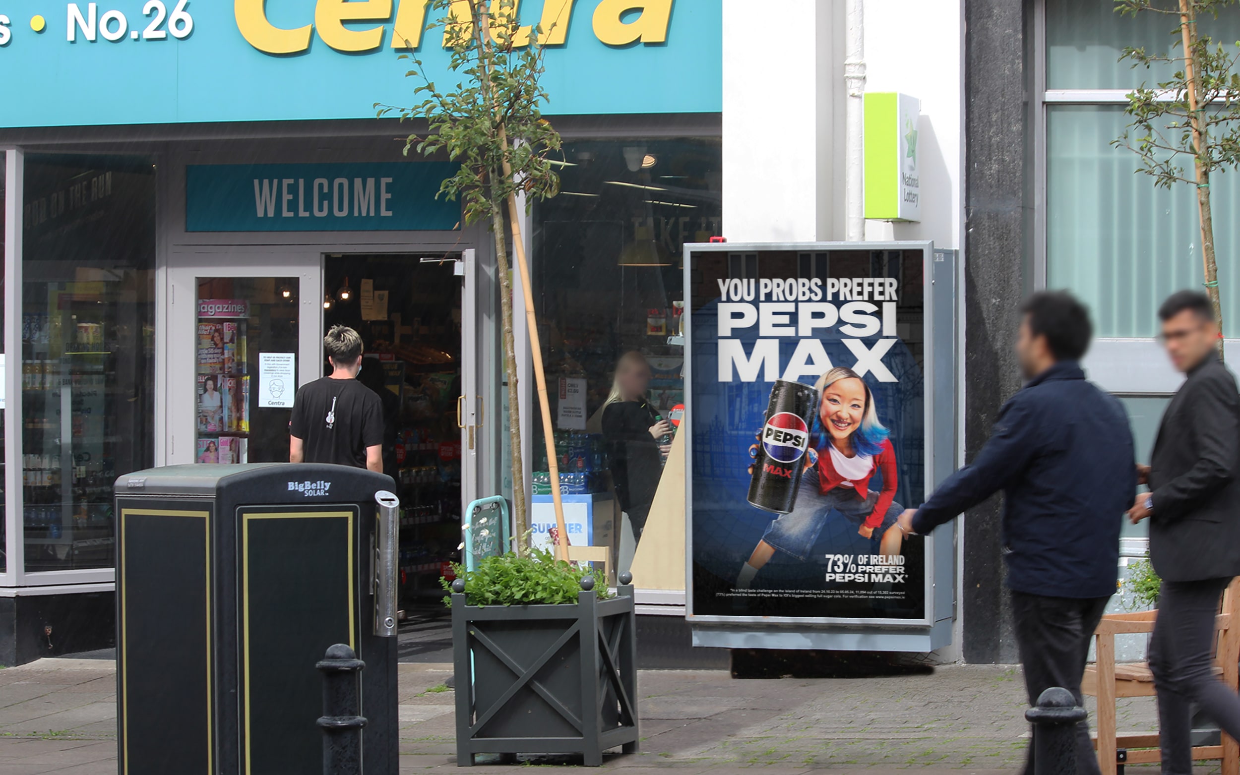 An Adbox 6-Sheet poster unit displaying an advertisement for Pepsi Max, situated outside of the entrance of a Centra convenience store
