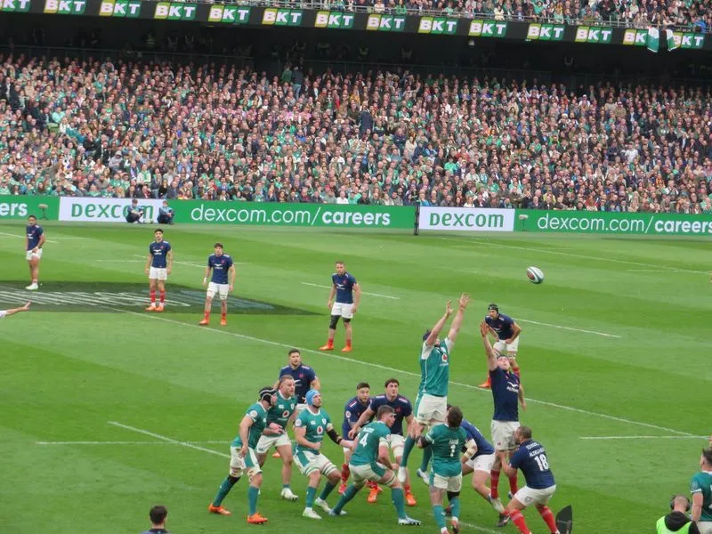 A pitch-side LED advertising board displaying Dexcom, with players competing for a lineout in the foreground during Ireland & France, in the Aviva Stadium