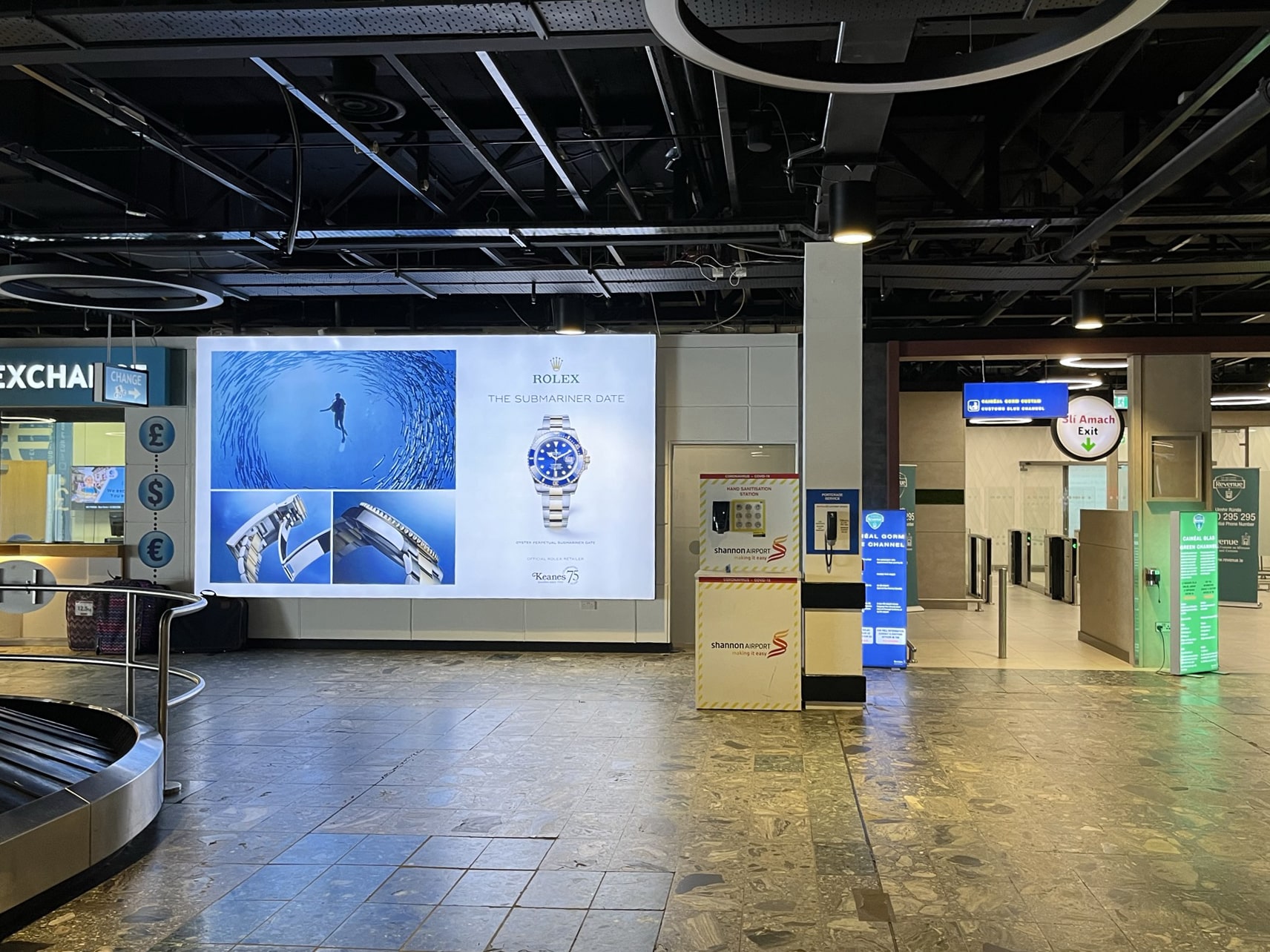 A lightbox billboard displaying an advertisement for Rolex Submariner Watch, located in the Arrivals Hall in Shannon Airport