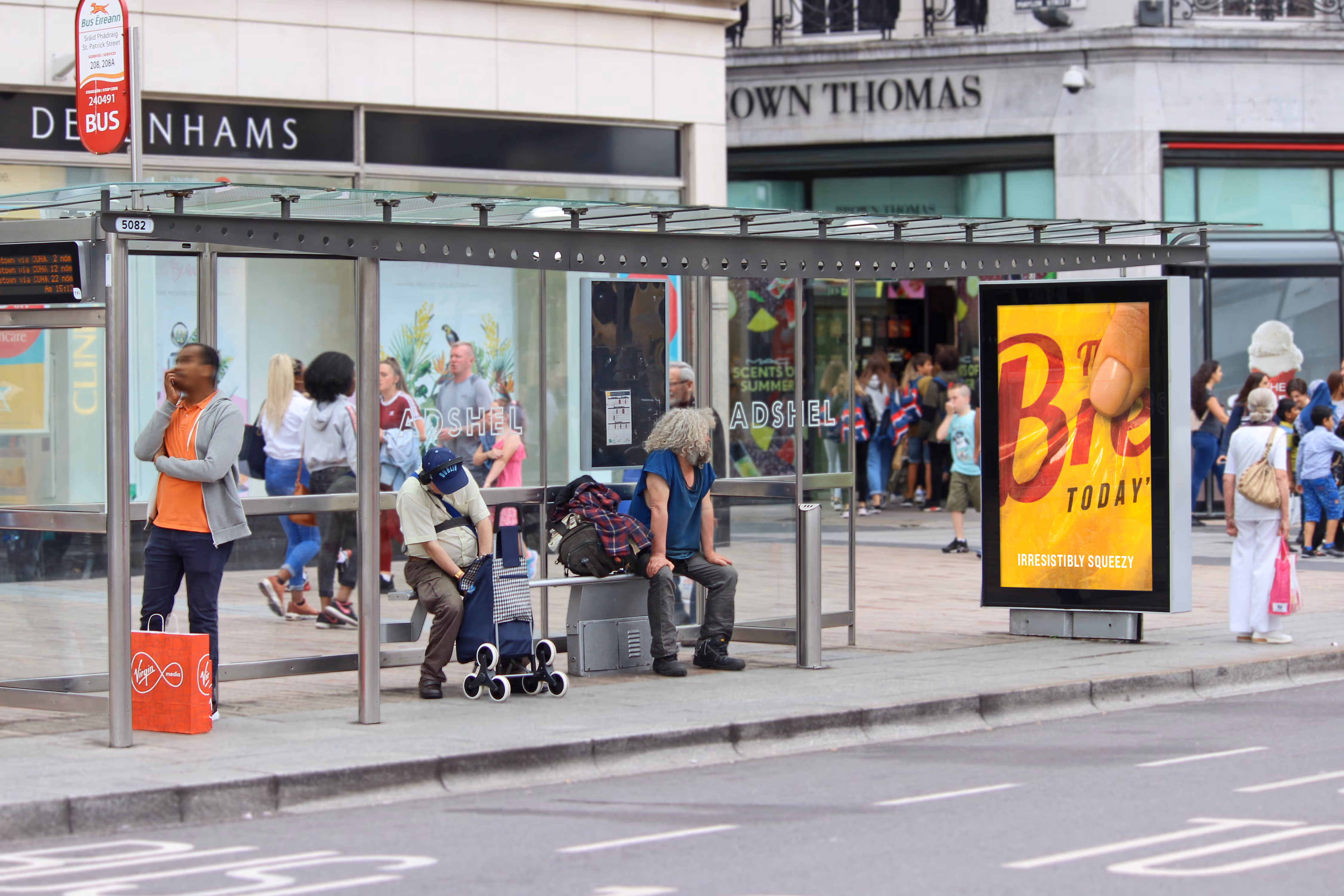 An Adshel 6-Sheet bus shelter displaying an advertisement for Sky Sports Golf, on a busy shopping street in Cork City