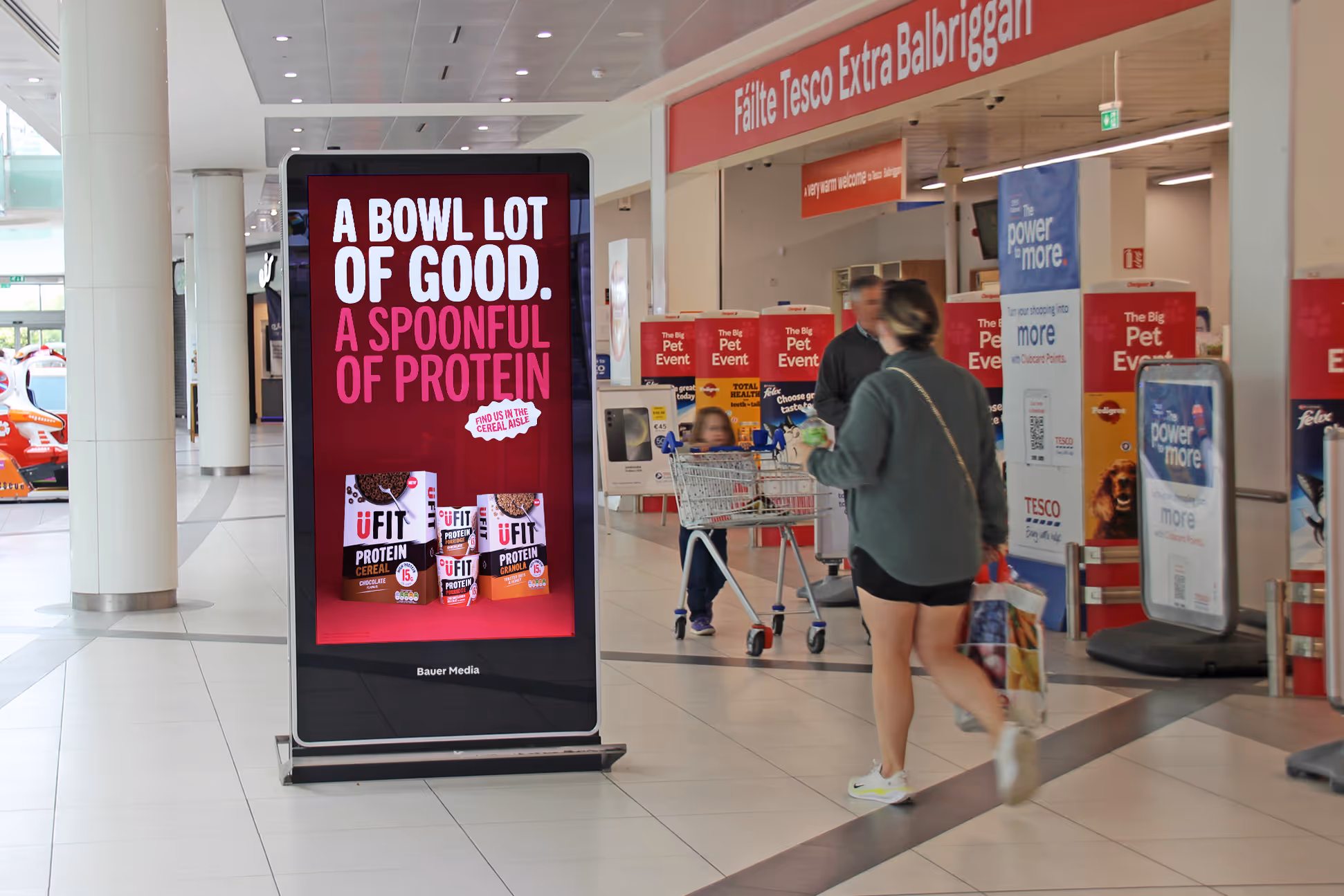 An Adshel Live Retail screen located outside a multiple supermarket displaying an advert for Ufit Protein