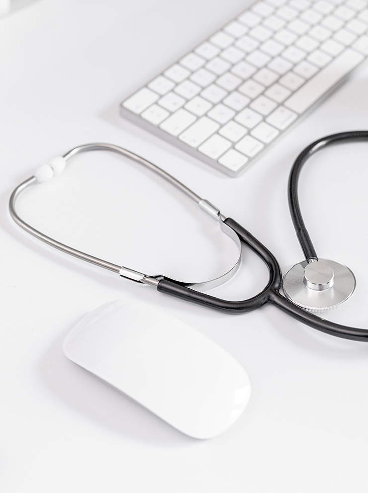 Stethoscoop op bureau naast toetsenbord en muis — symbool voor de digitale logo-check bij De LogoDokter.