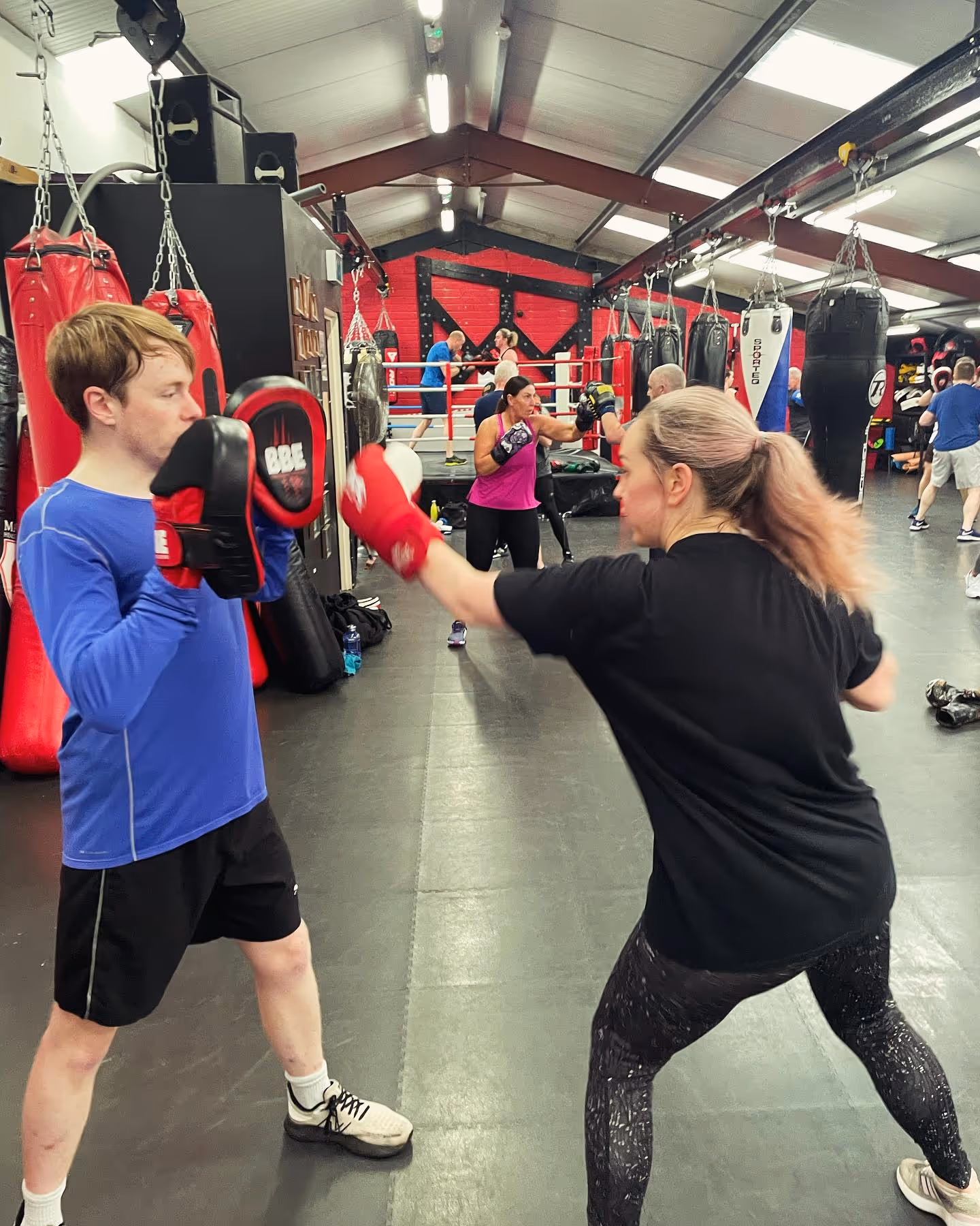 Magee Health & Fitness Belfast boxing class with members doing padwork drills in the ring area