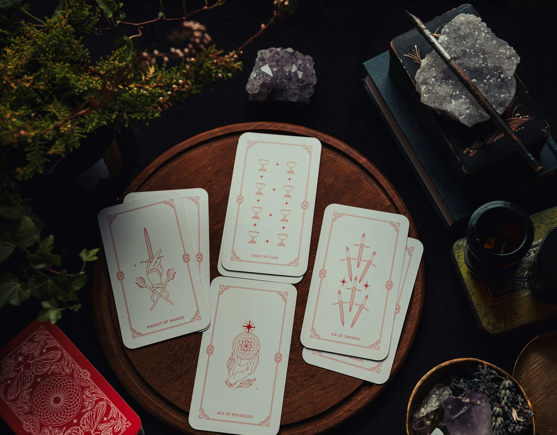Tarot card spread on wooden plate with crystals, including Knight of Wands, Eight of Cups, and Six of Swords cards in mystical setting.