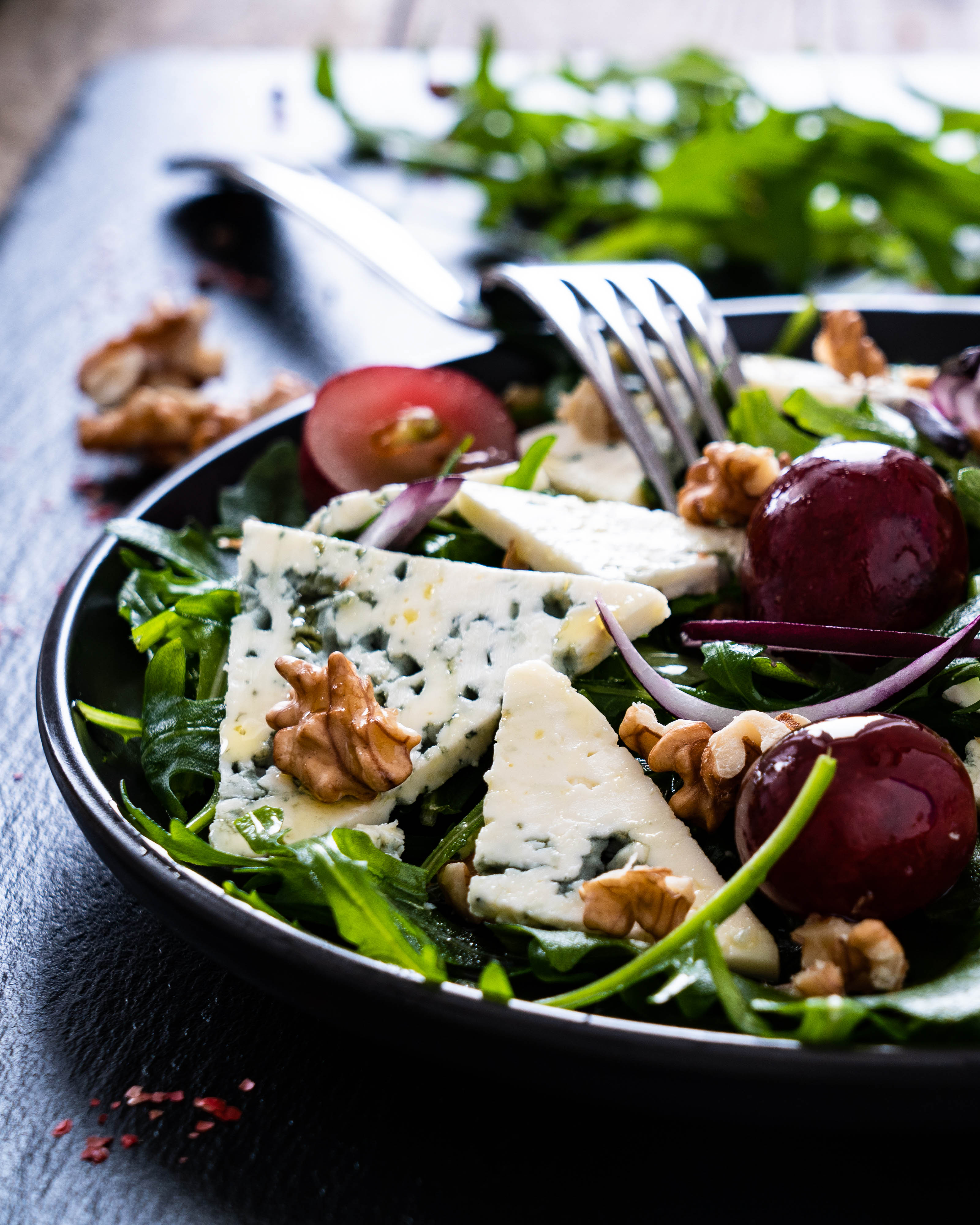 Salad with green vegetables, cheddar cheese, pecans, and roasted organic grapes