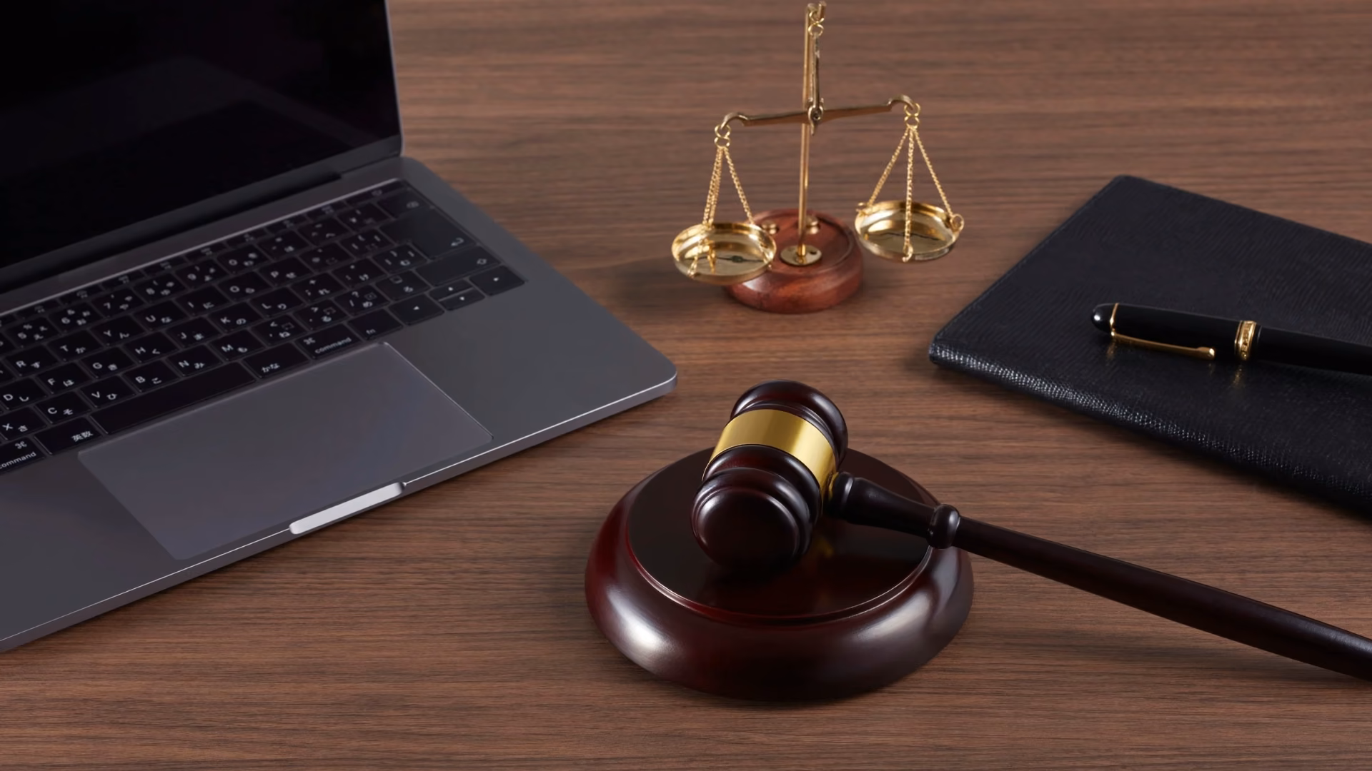 Gavel, scales of justice, notebook and laptop on a wooden desk