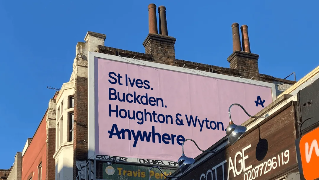 Photograph of billboard on london street, reads "St Ives. Buckden. Houghton & Wyton. Anywhere" features anywhere logo in navy with light pink background