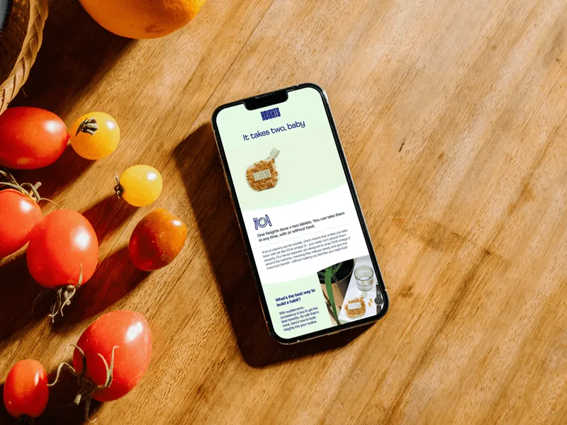 Mockup of an iPhone next to cherry tomatoes on a kitchen table showing a screen of the Heights app with nutrition advices