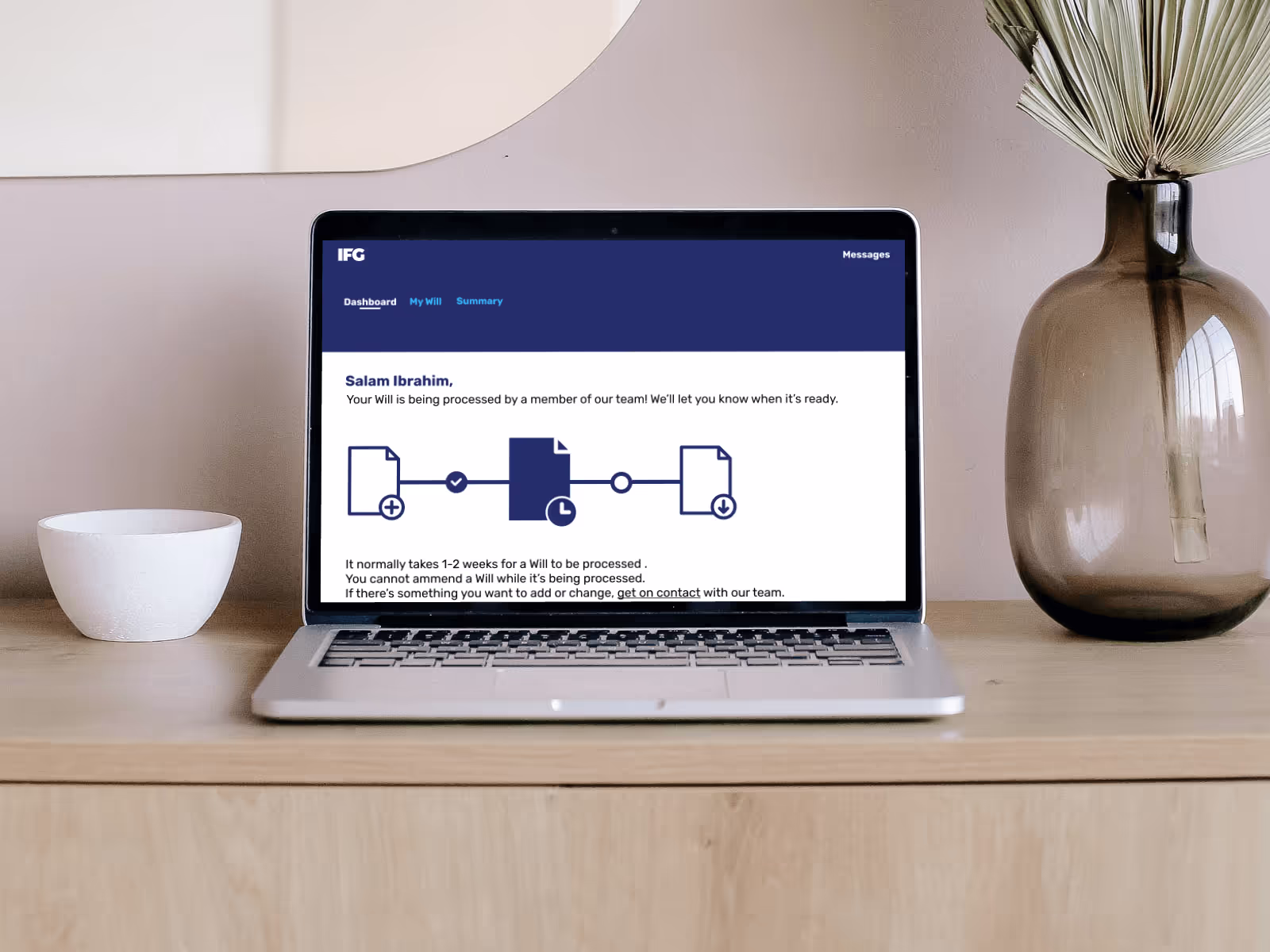 Picture of a macbook on a minimal decoration desk showing a page of IFG's dashboard