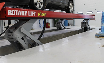 Concrete dock extending into a lake with cleats for boat mooring and a fuel pump station on the right side.